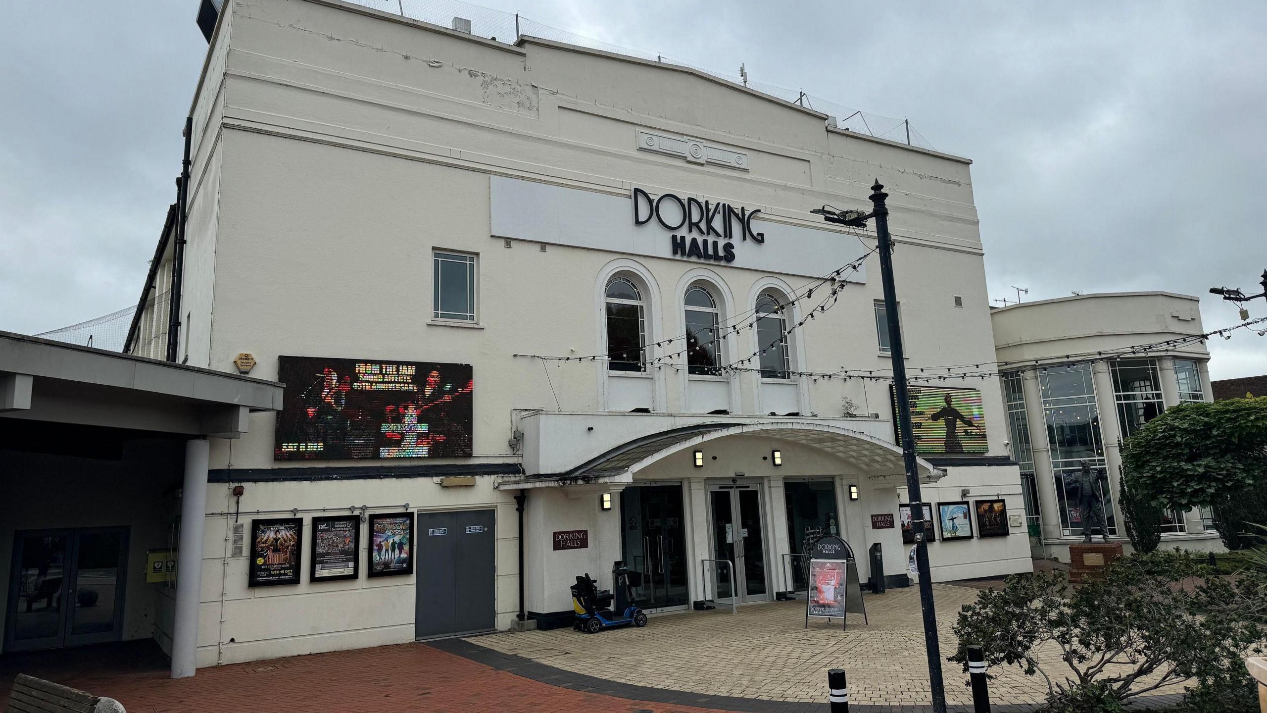 An exterior view of the venue Dorking Halls on a cloudy day.