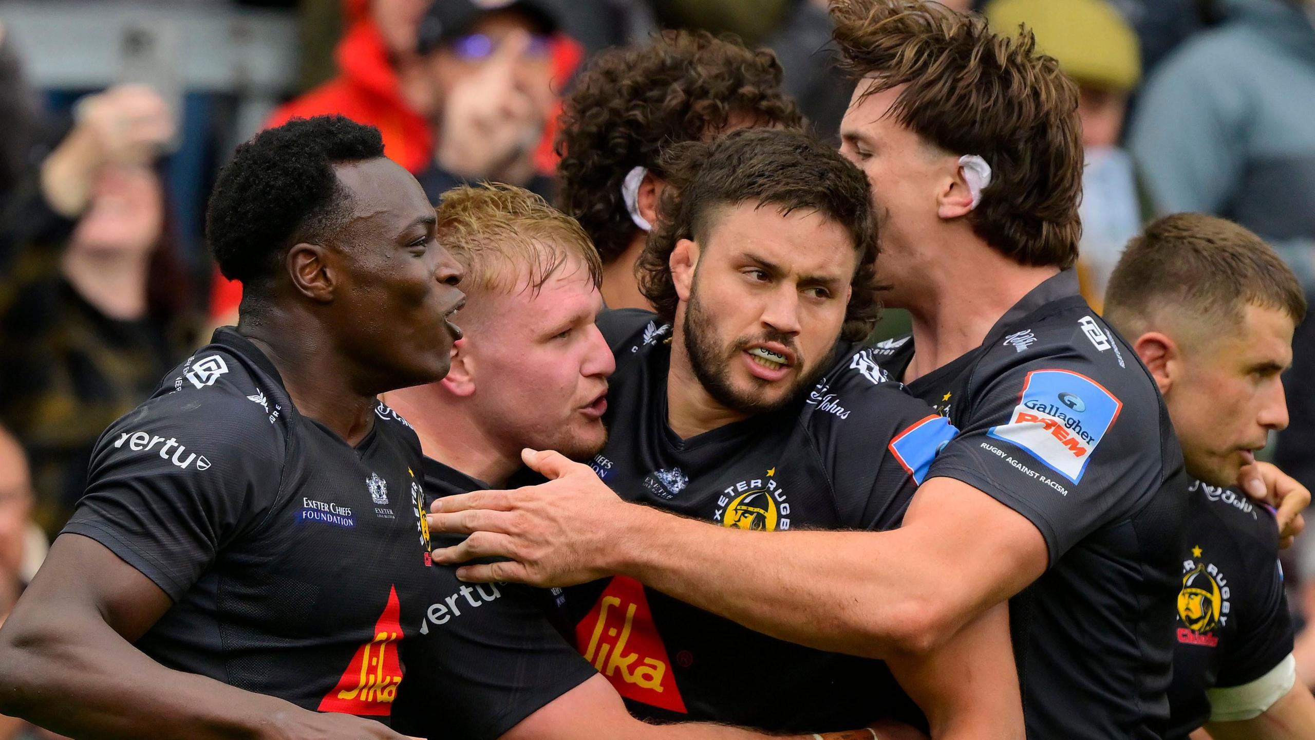 Exeter players celebrate a try against Saracens