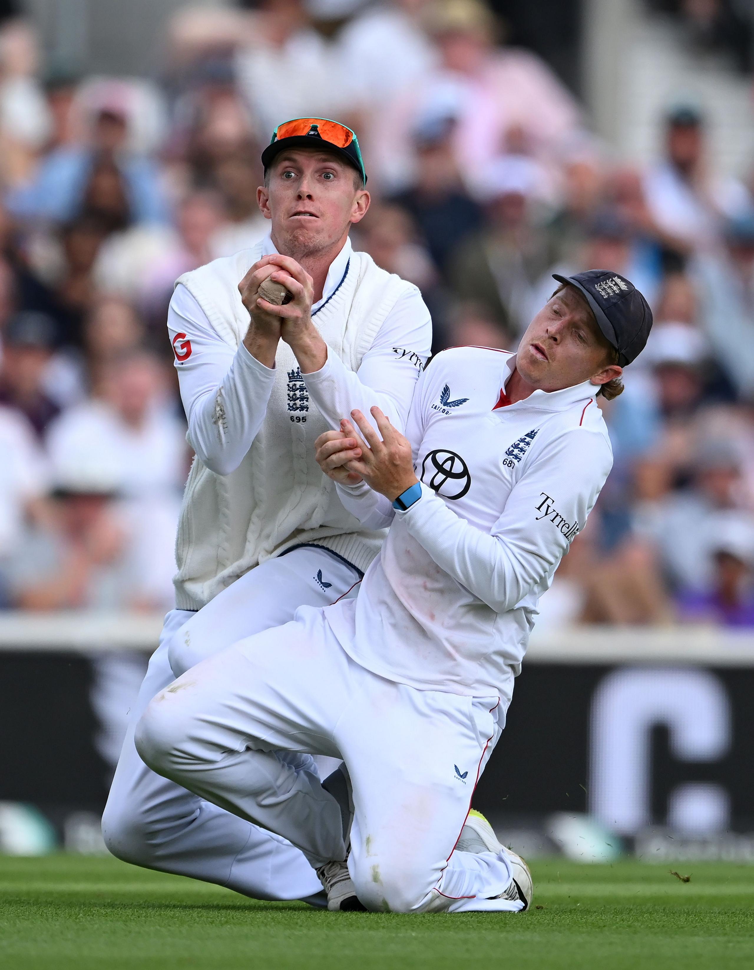 England's Zak Crawley collides with captain Ollie Pope to take a catch to dismiss India's Washington Sundar for 53 during day three of the 5th Rothesay Test match between England and India at The Kia Oval in London. Photo by Shaun Botterill