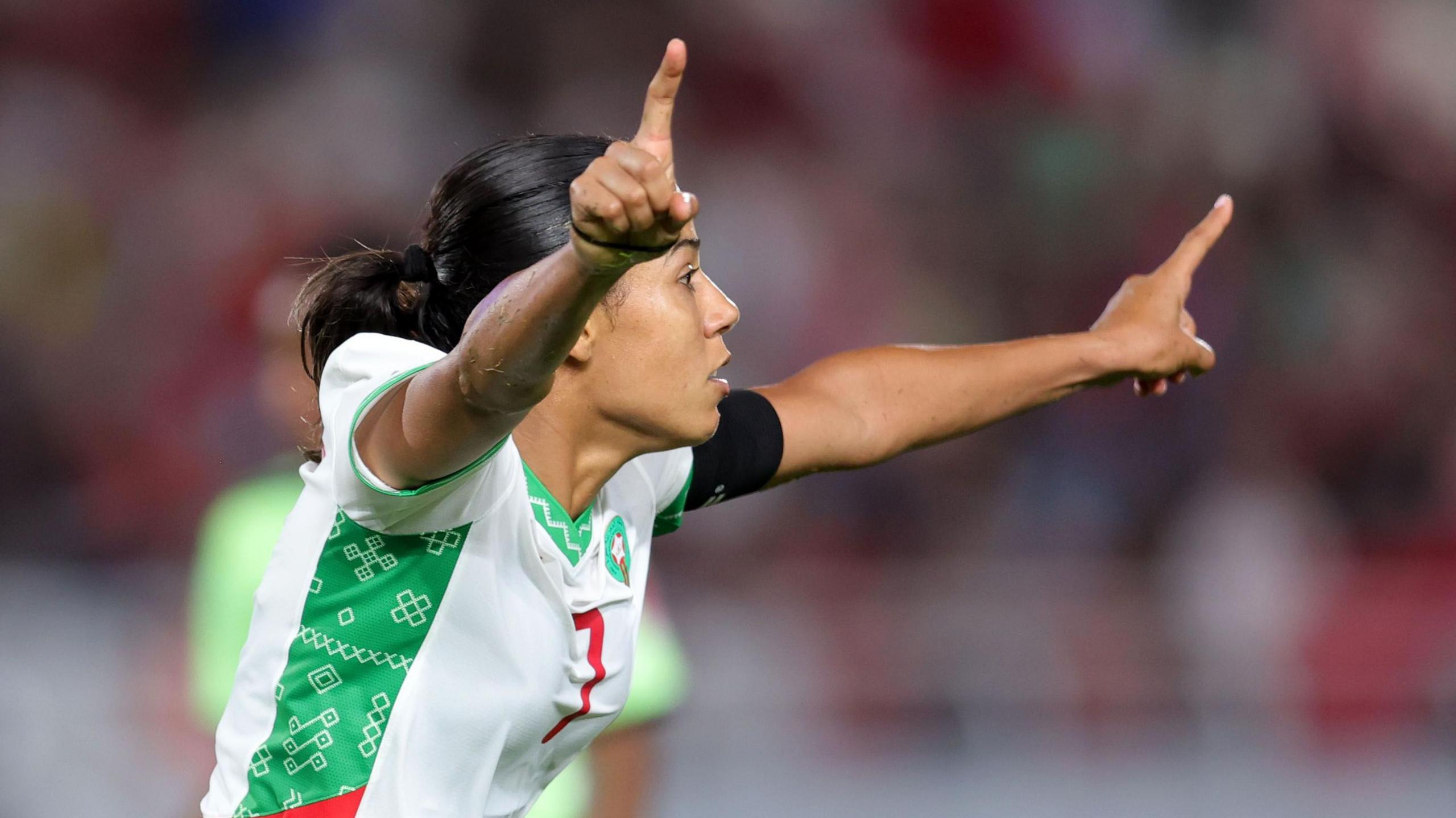 Ghizlane Chebbak raises her arms in celebration after scoring a goal for Morocco