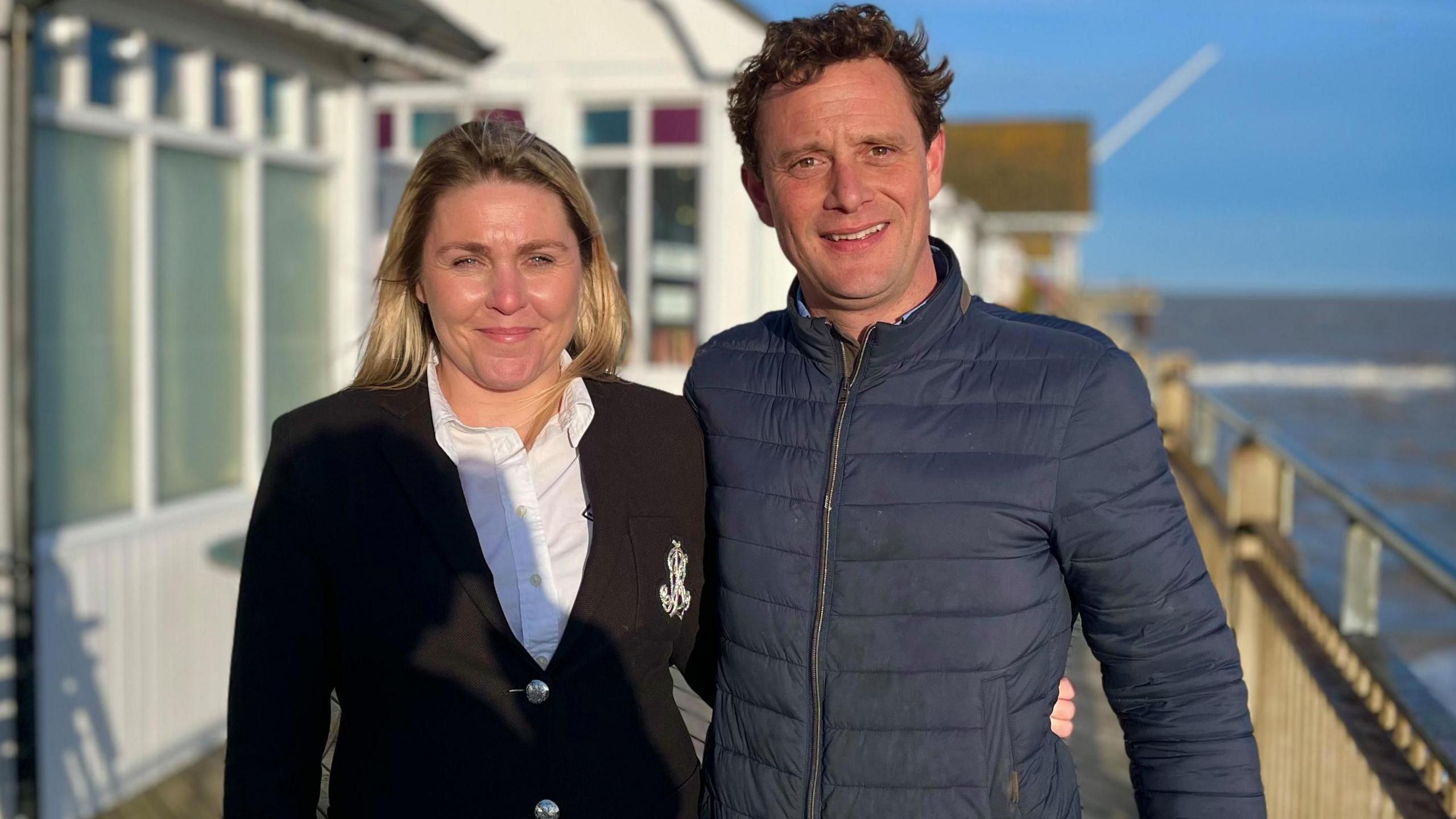 Amy Barick and Charles Barwick smiling on Southwold Pier as the sun is shining