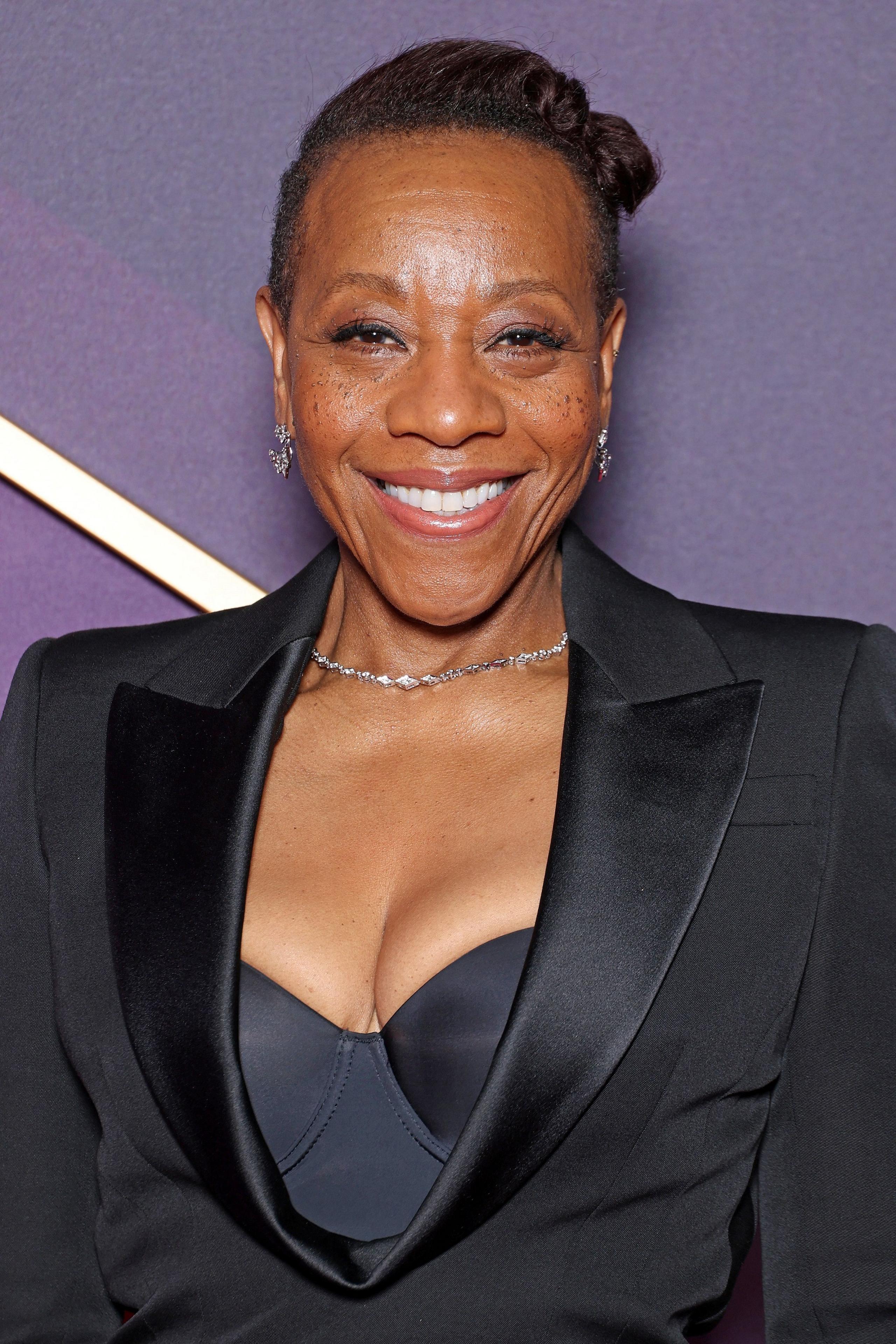 Marianne Jean-Baptiste wearing a fitted all-black outfit with a bustier top underneath