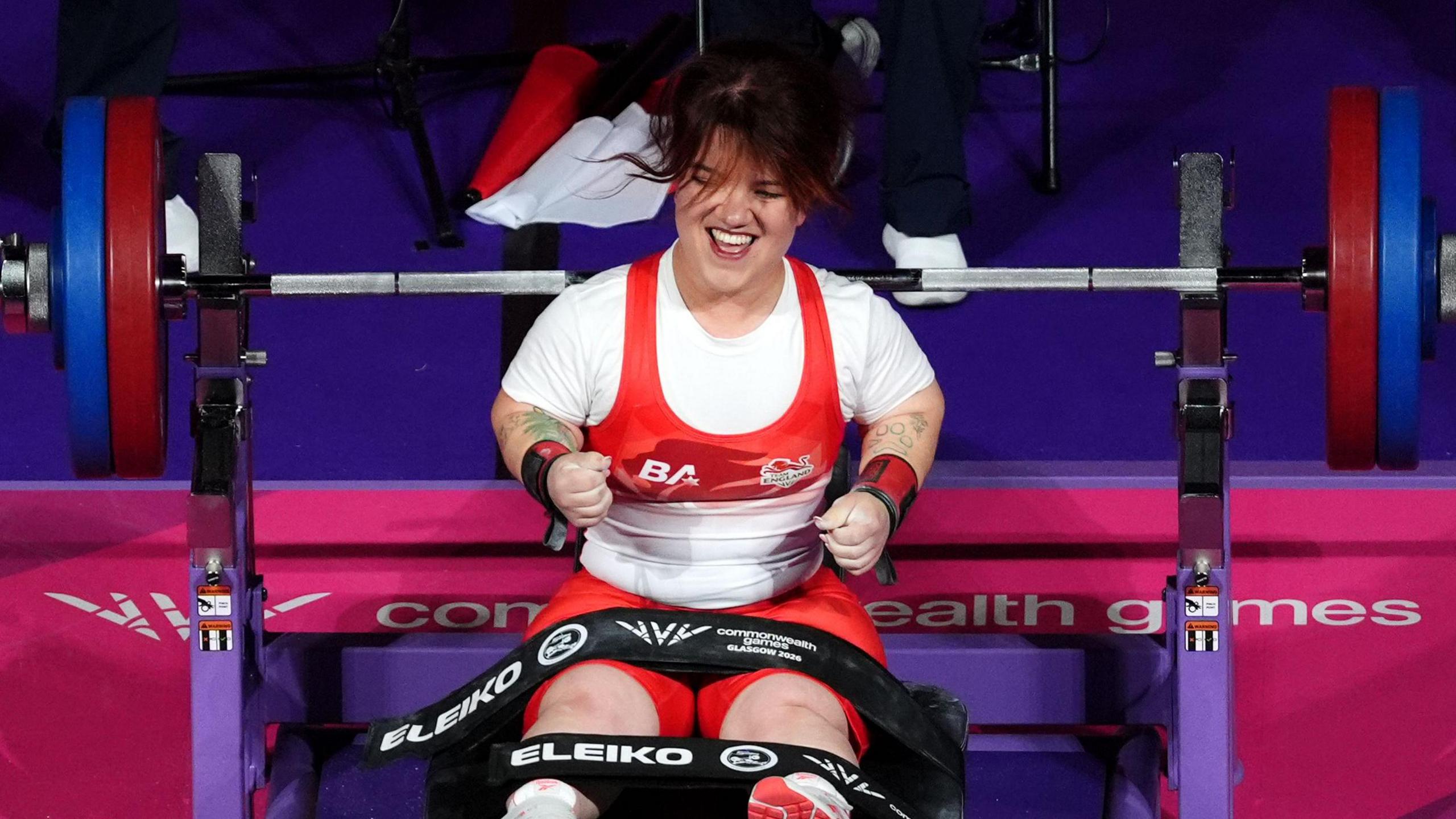 Olivia Broome, wearing her team England powerlifting suit, cheering after completing her lift at the Glasgow Commonwealth Games 2026