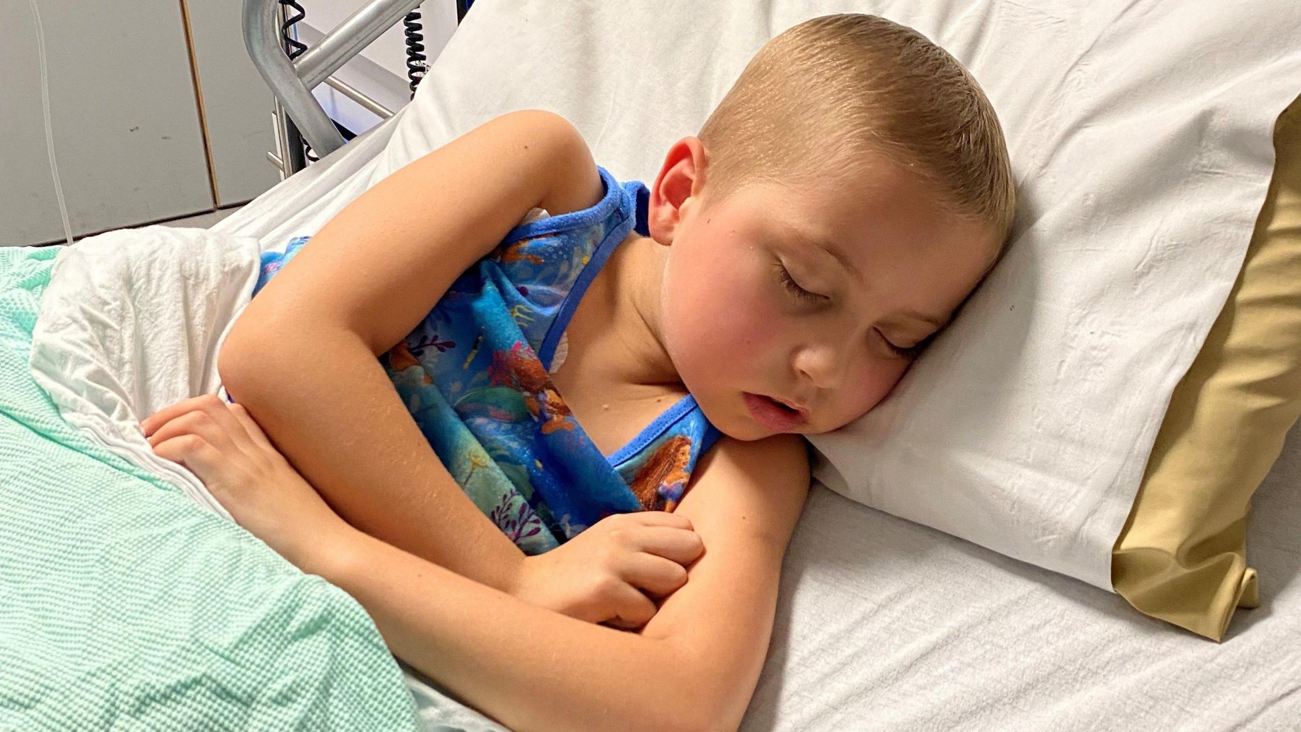 Betsy lying on a hospital bed during treatment 