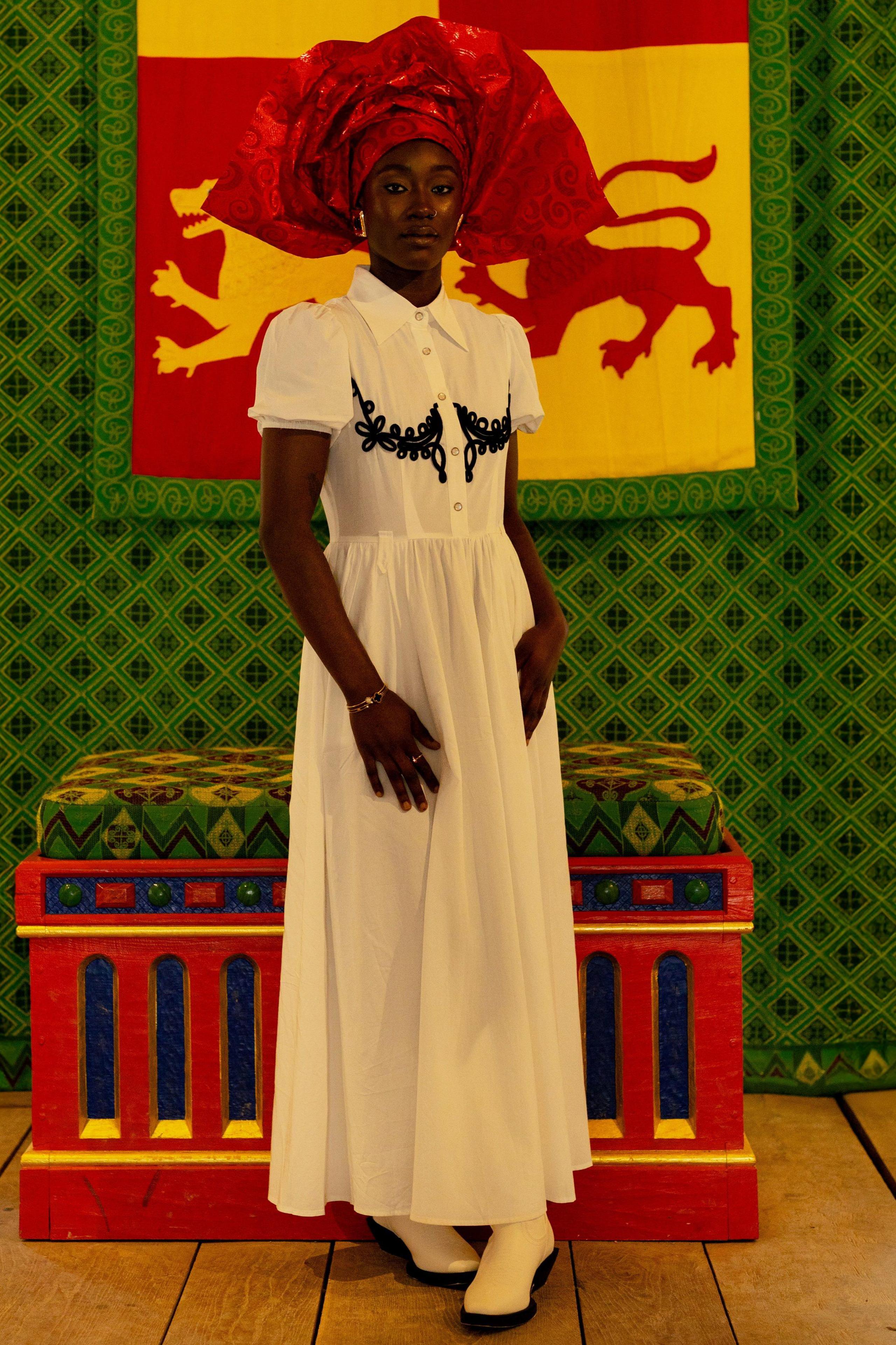 Dynes mewn penwisg o flaen baner