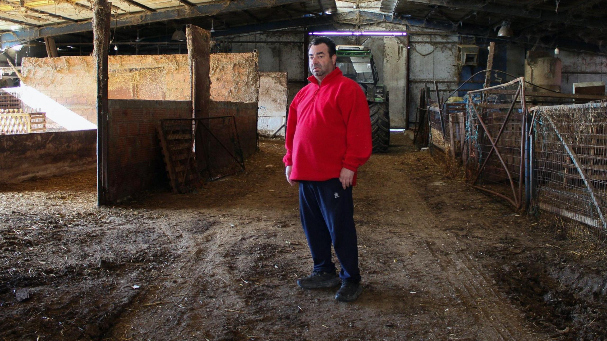 Farmer Tassos Manakas stands inside his empty barn