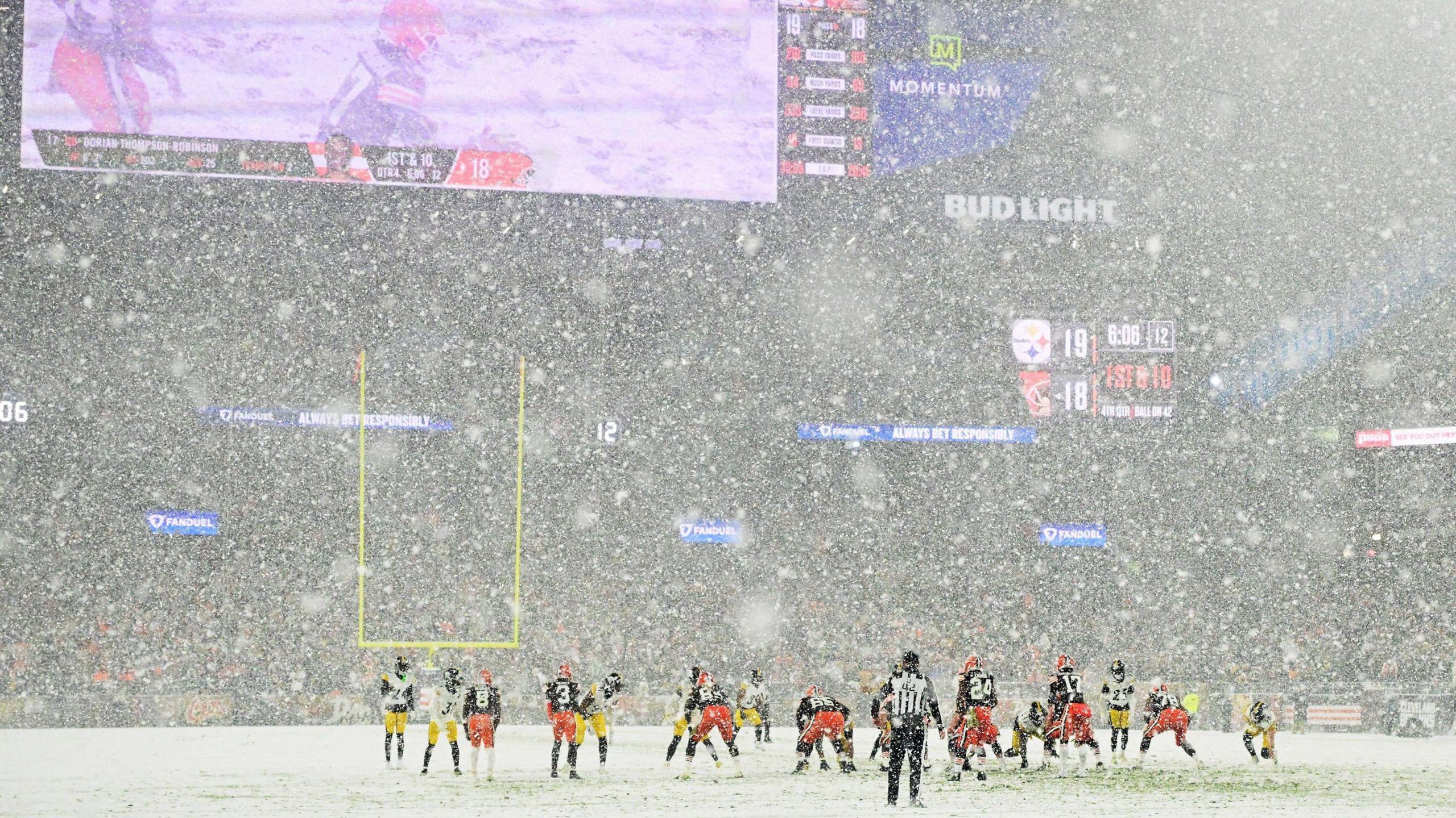 The two teams lining up for a play in the snow