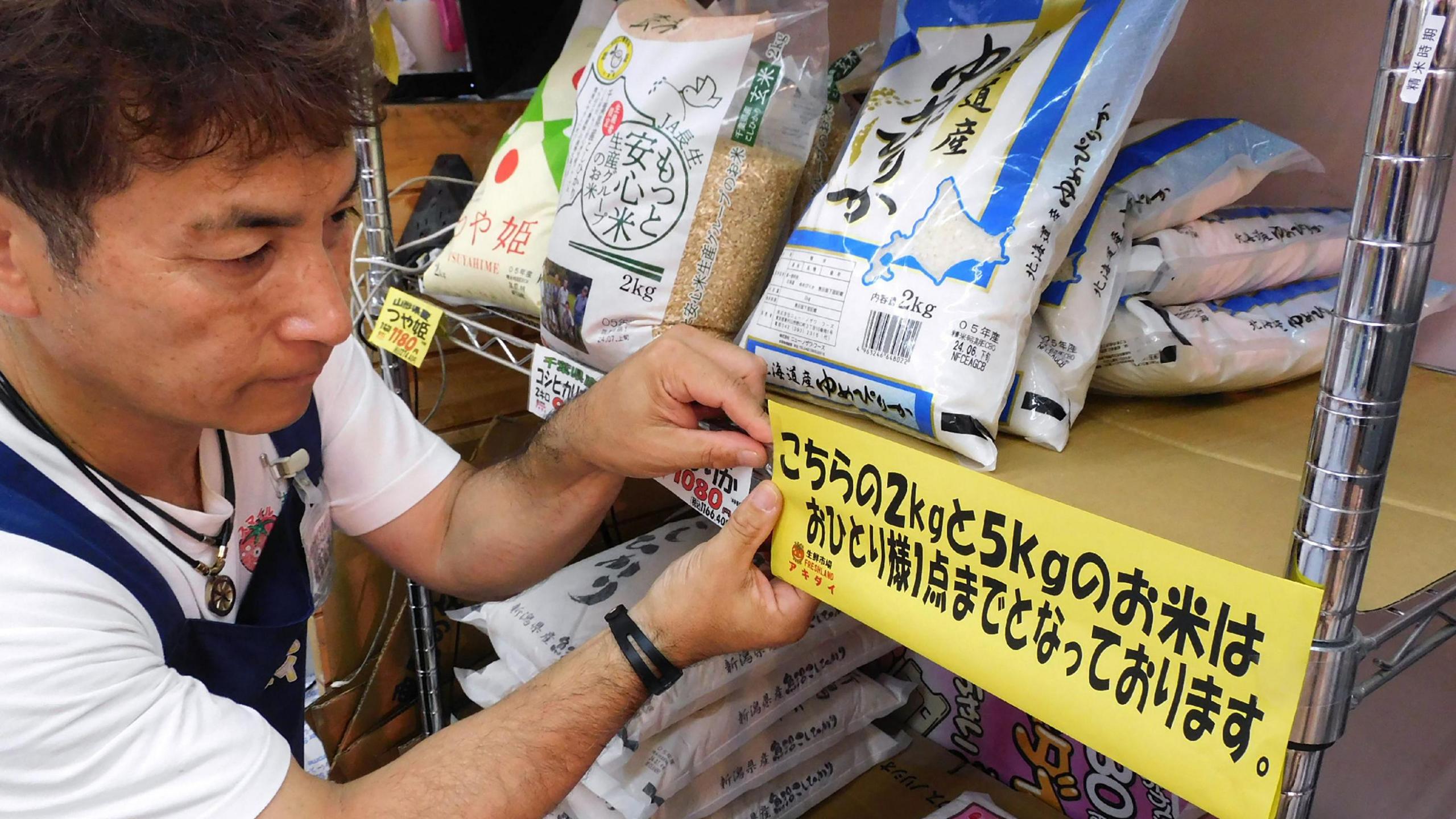A supermarket worker put up a sign informing customers purchasing rice to buy only one bag per person in Tokyo.