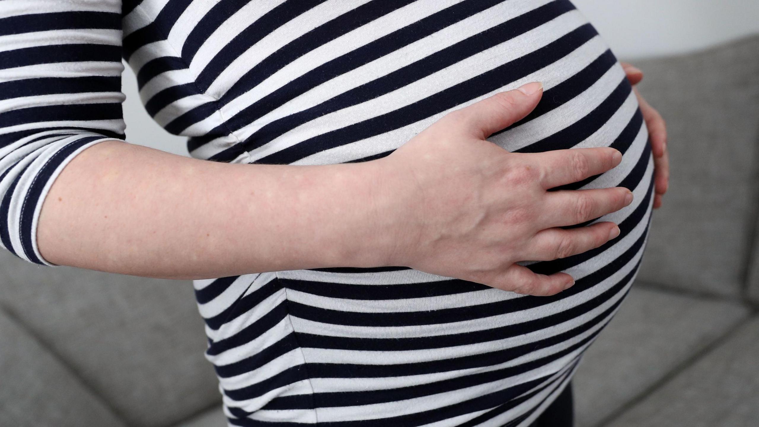 A woman holding her bump