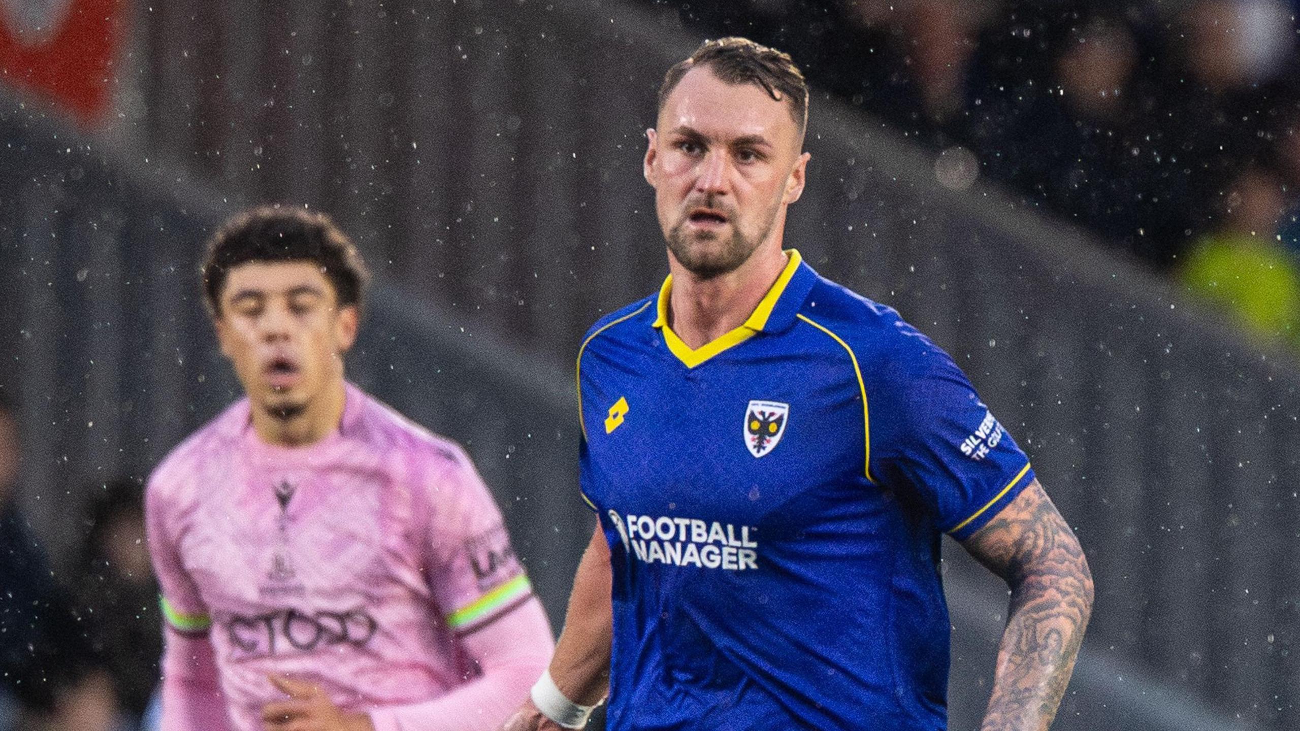 Patrick Bauer in action for AFC Wimbledon, wearing their blue home shirt