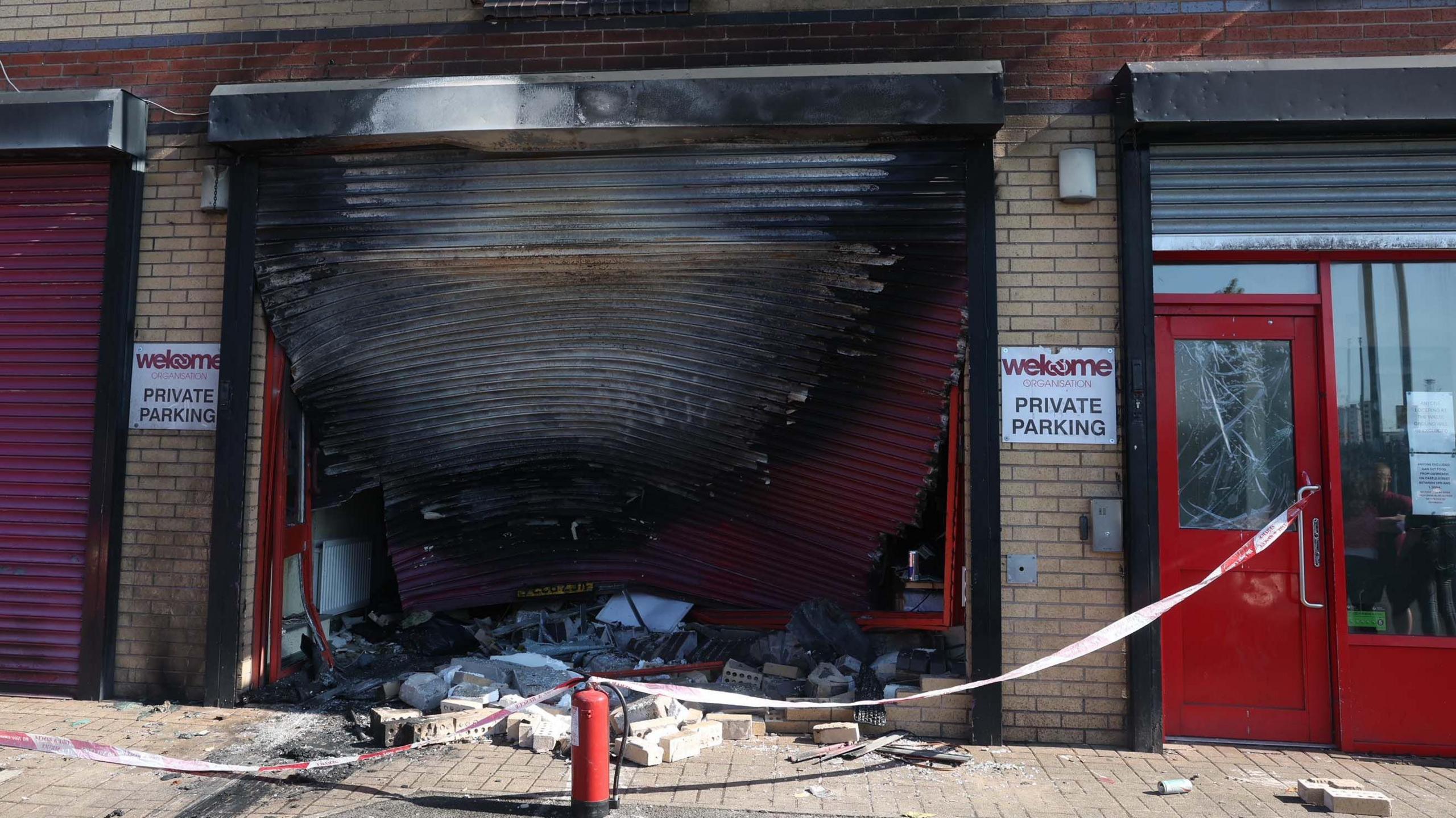 Fire damaged garage which has been warped at the Welcome Organisation in West Belfast