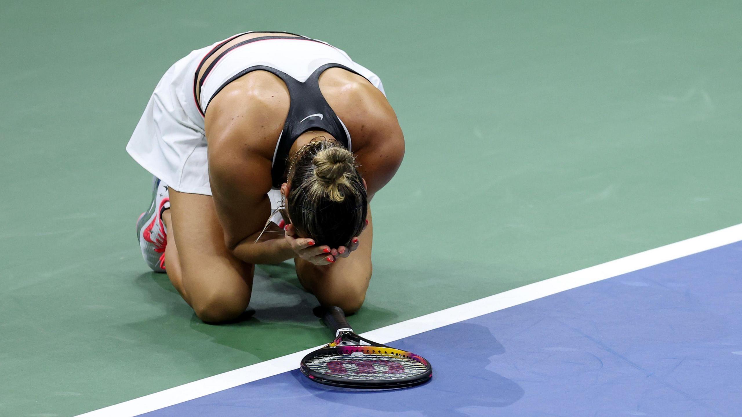 Aryna Sabalenka falls to the court after the 2025 US Open final