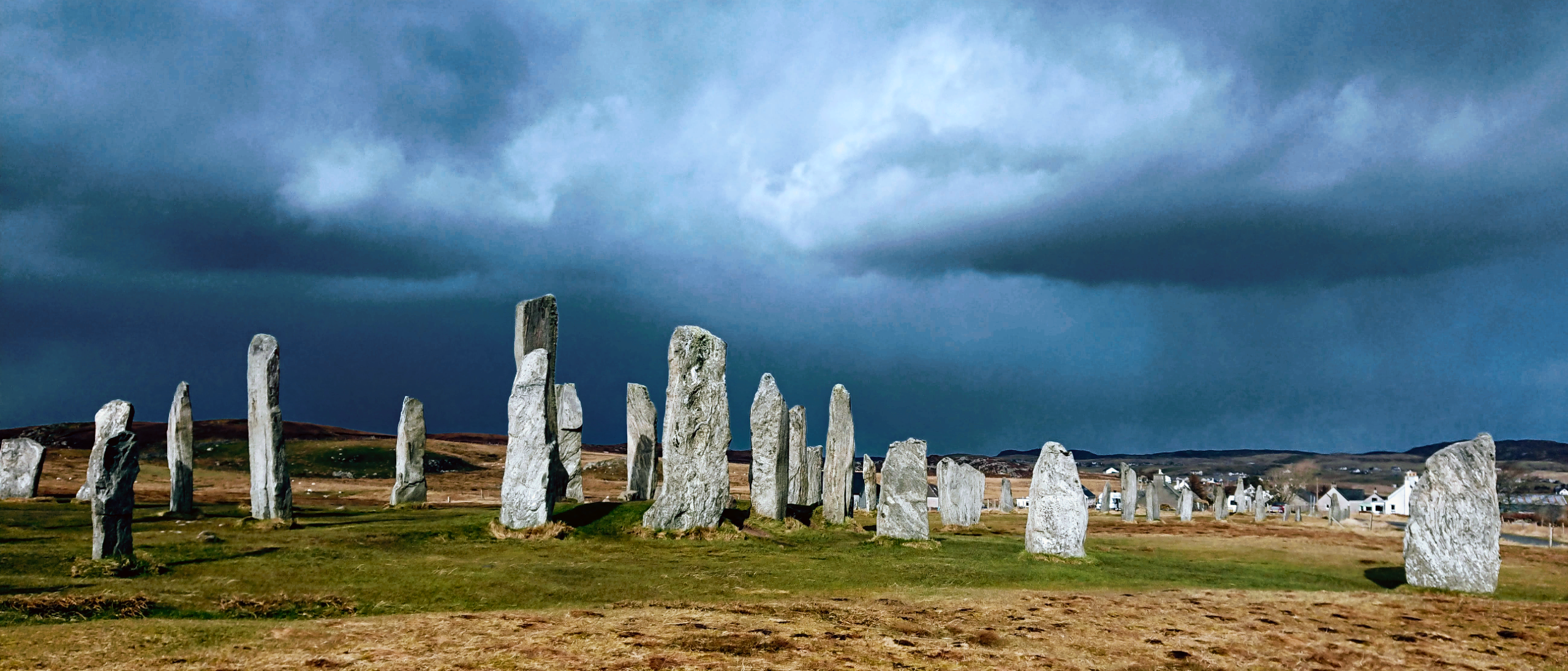 Calanais stones below a dark and stormy blue/grey sky