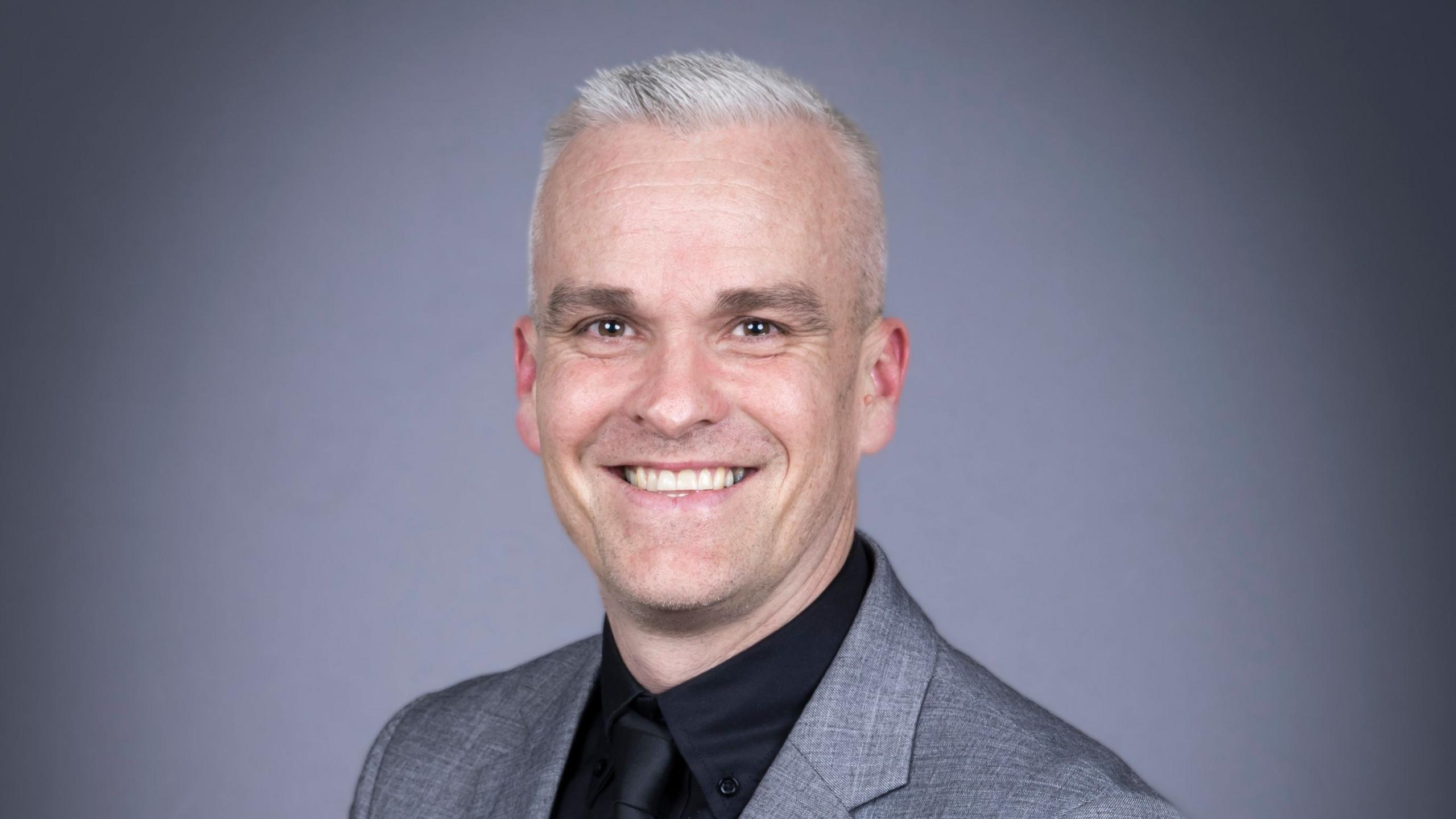 An image showing Chris Tullin, the Vice Principal at Homefield College, sitting smiling. 