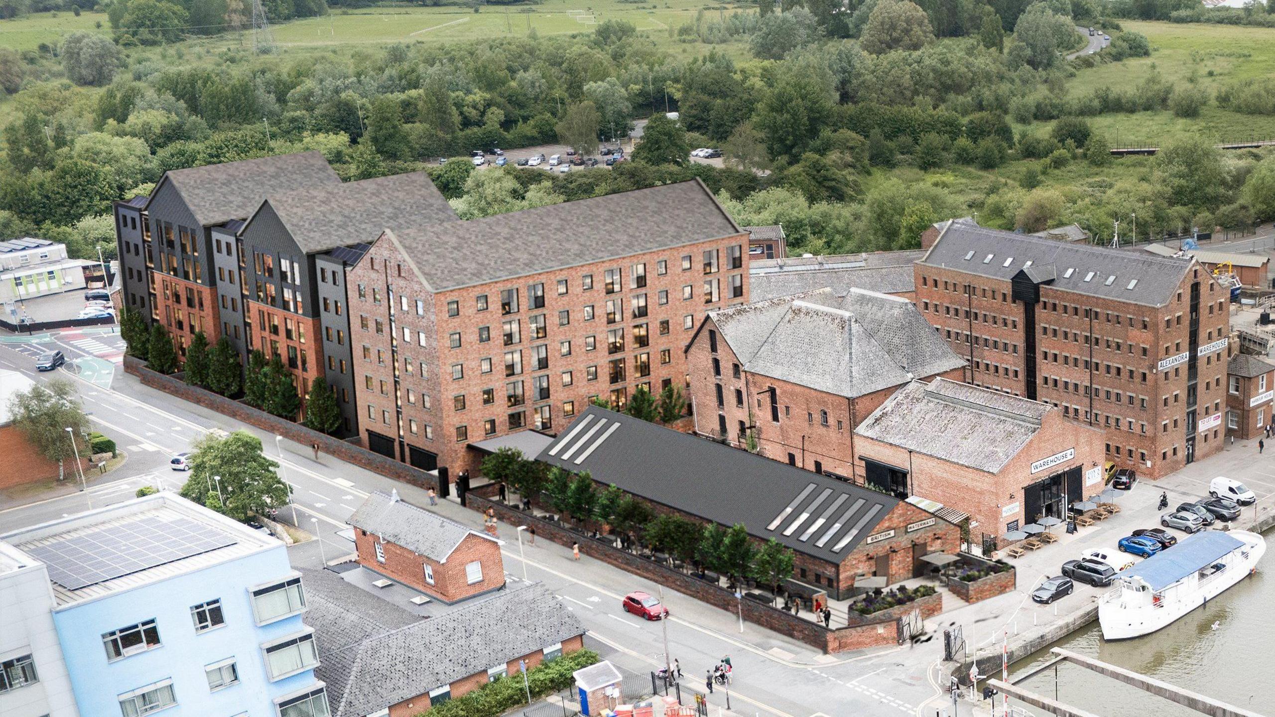 A computer-generated image of a six storey, warehouse-style building behind Alexandra Warehouse, near the Gloucester and Sharpness Canal. There is green space with trees behind the proposed development.