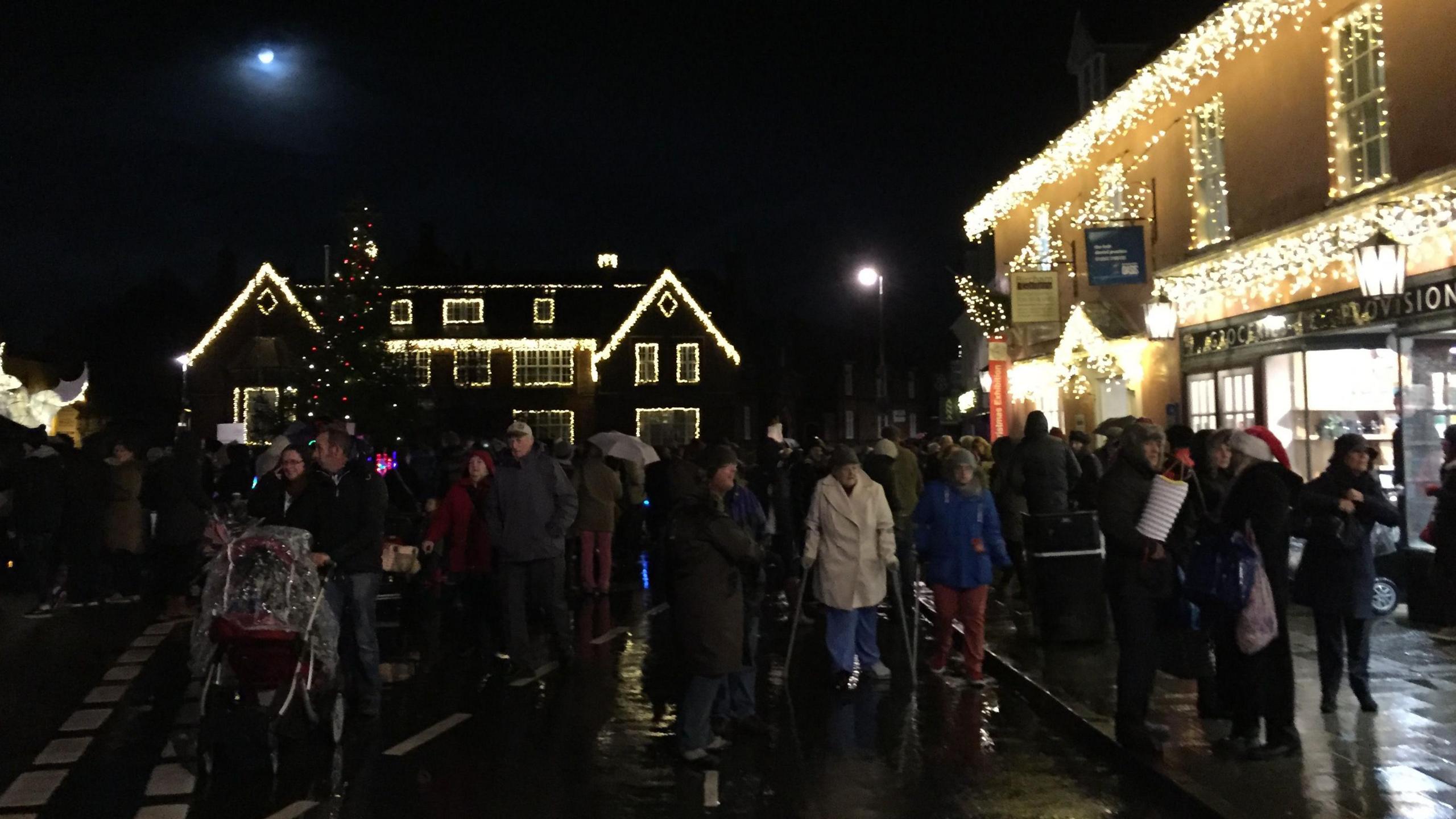 People in street in Holt at night for Christmas light show