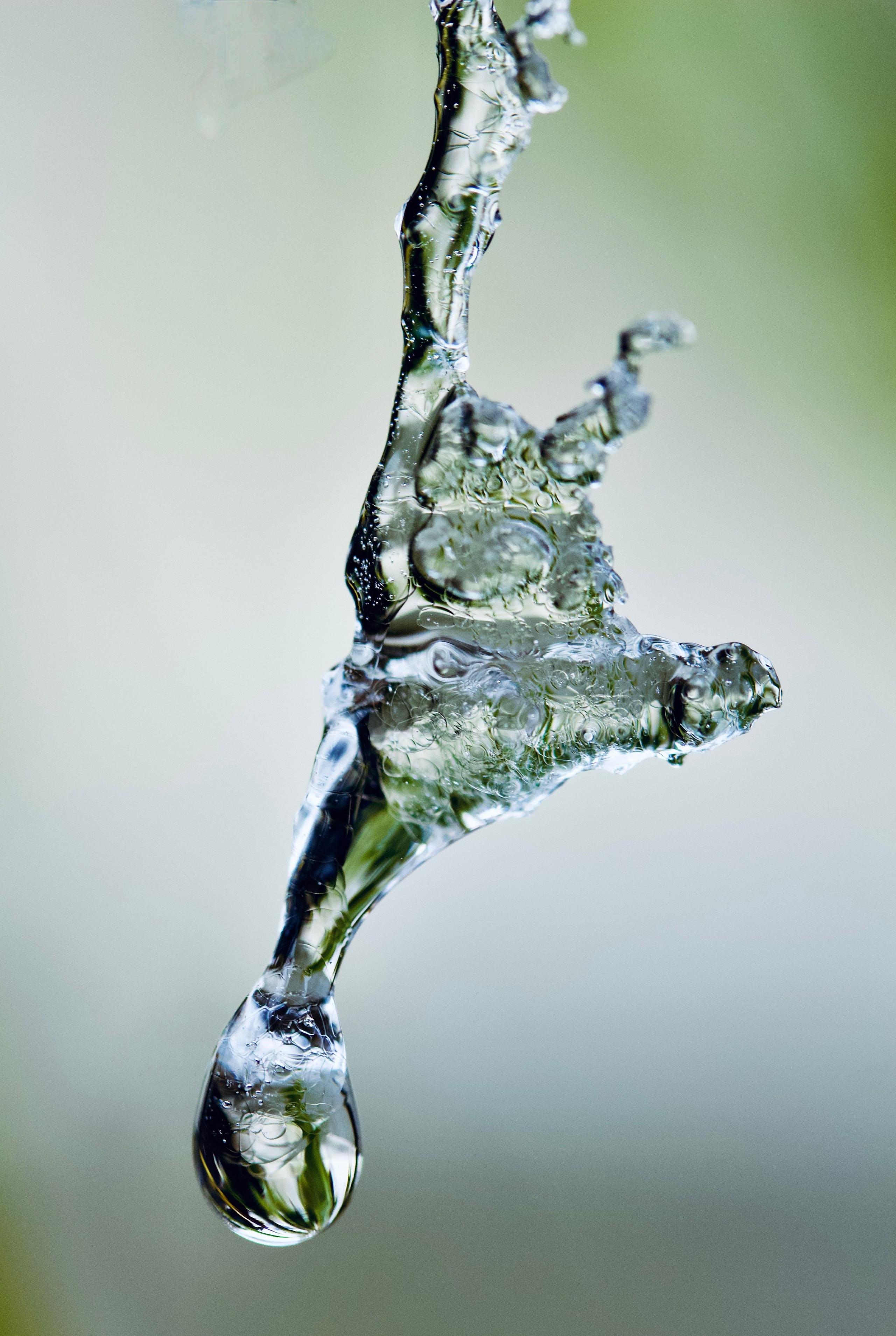 A drop of water falls from frozen water