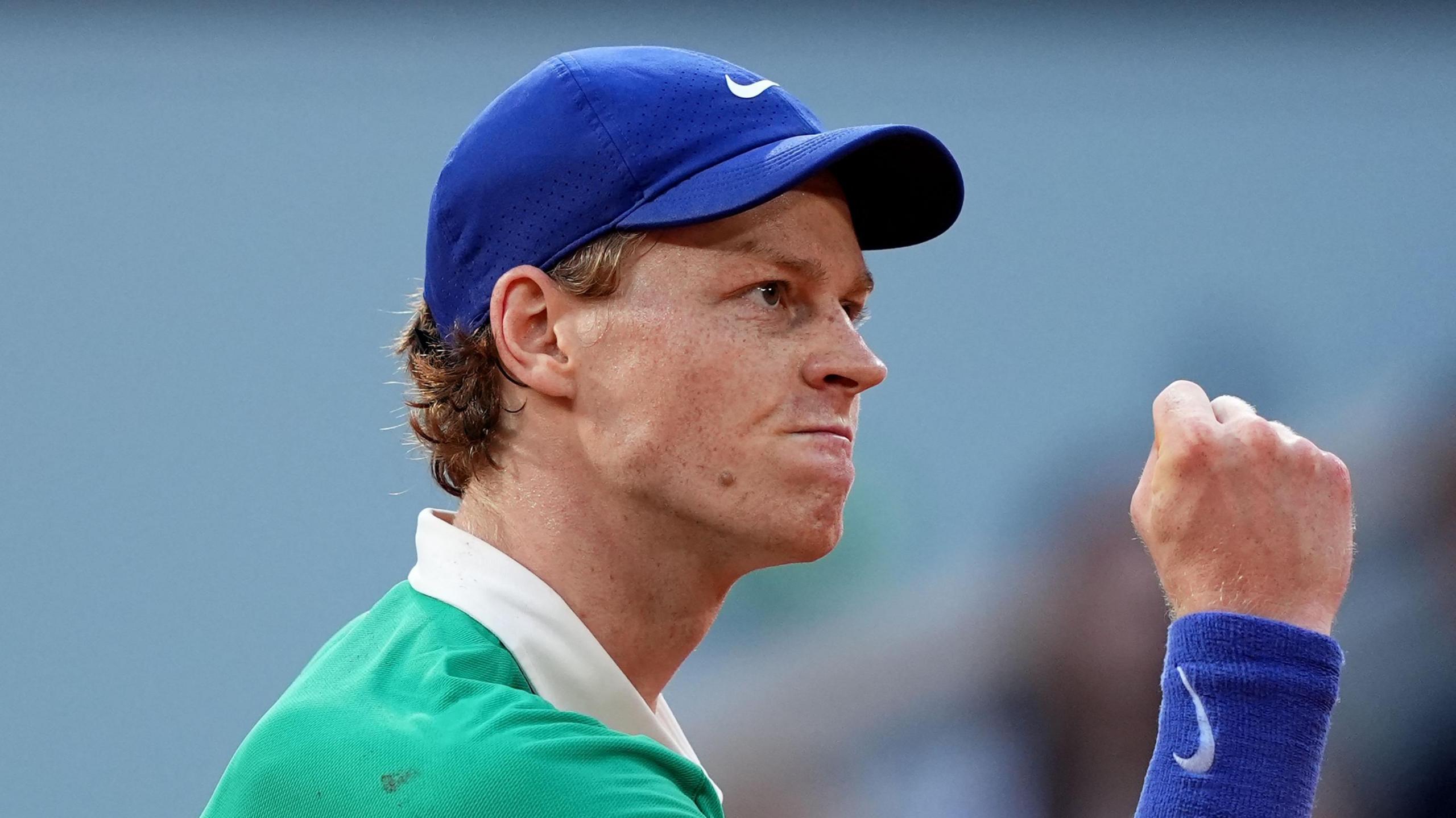 Jannik Sinner clenches his fist in celebration during his French Open match against Novak Djokovic
