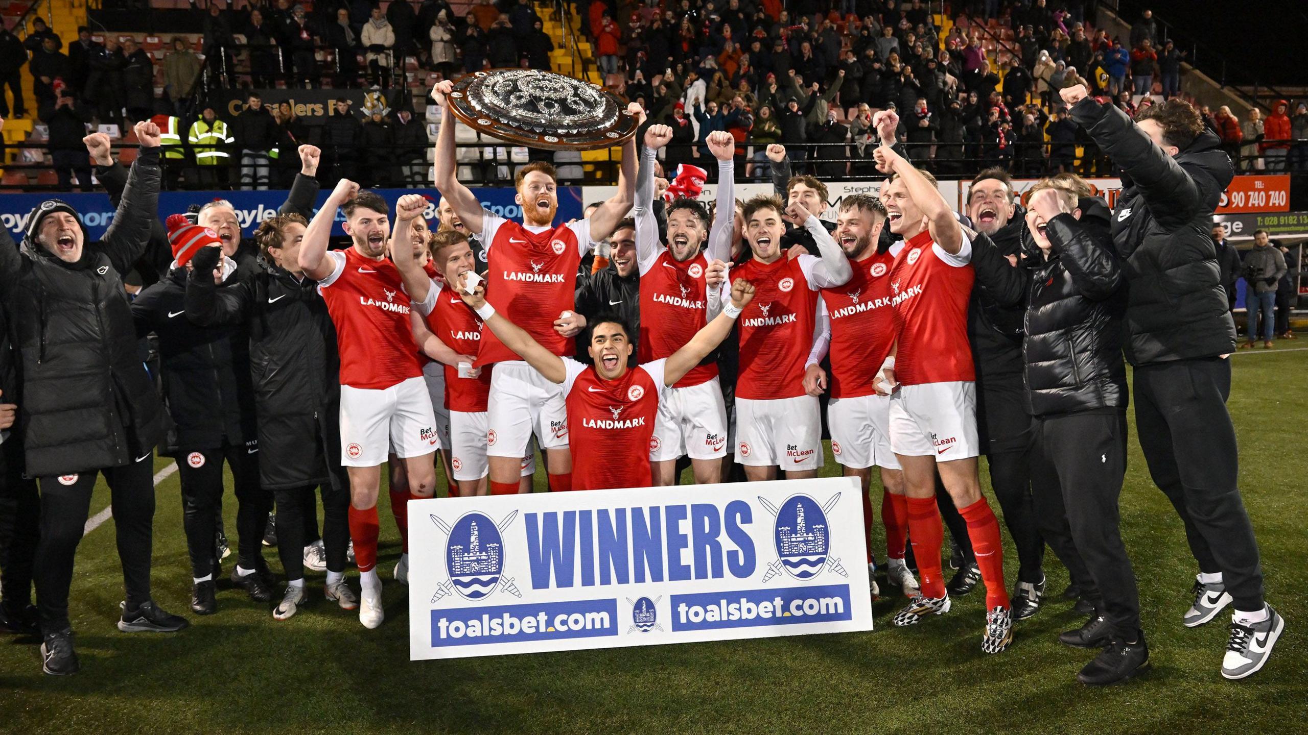 Larne celebrate their County Antrim Shield win in 2024