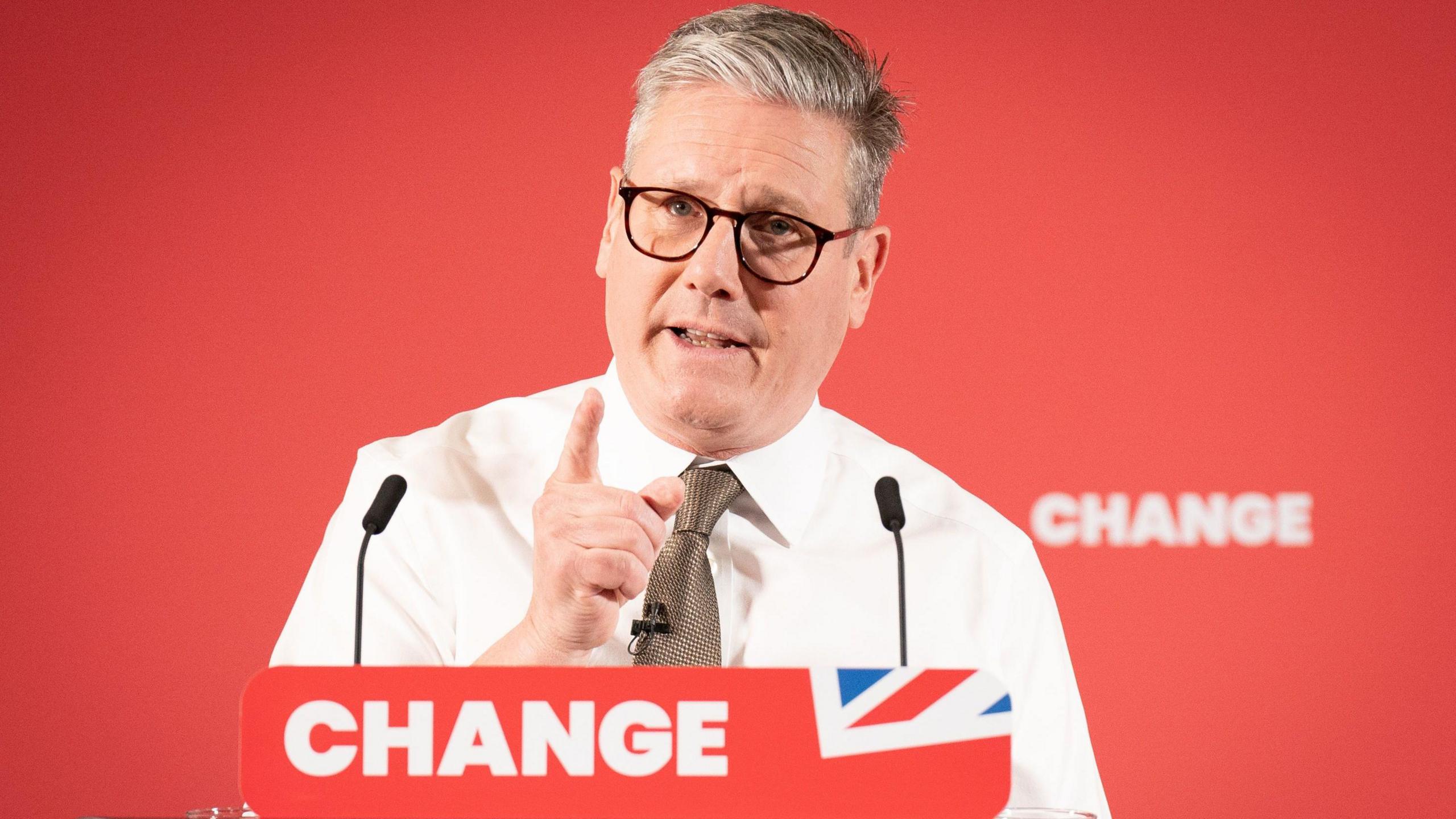 Keir Starmer standing at a podium which reads: "change". 