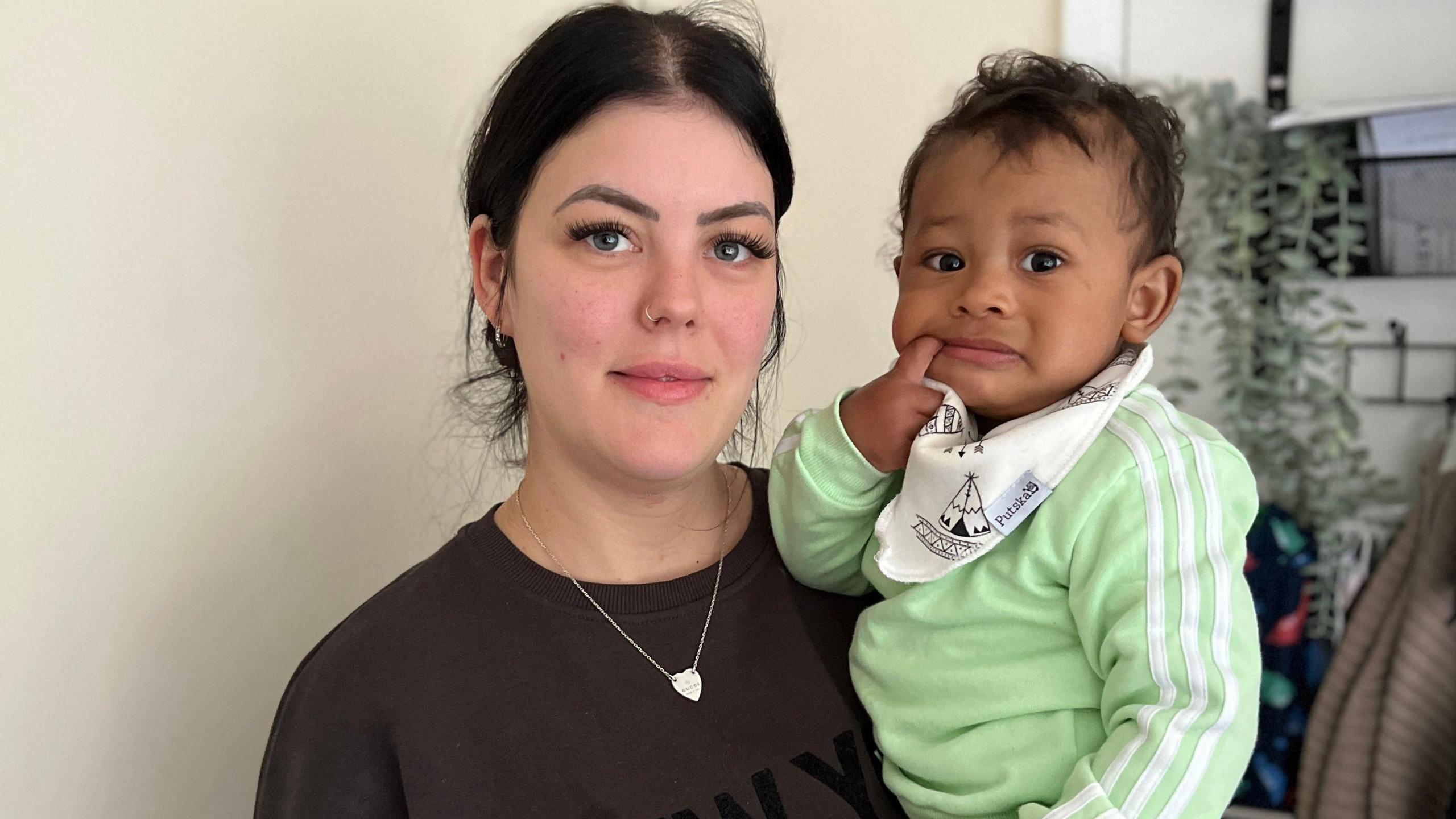 Lindsey Peyton and her baby son, Lindsey is wearing a black top whilst the baby is in green