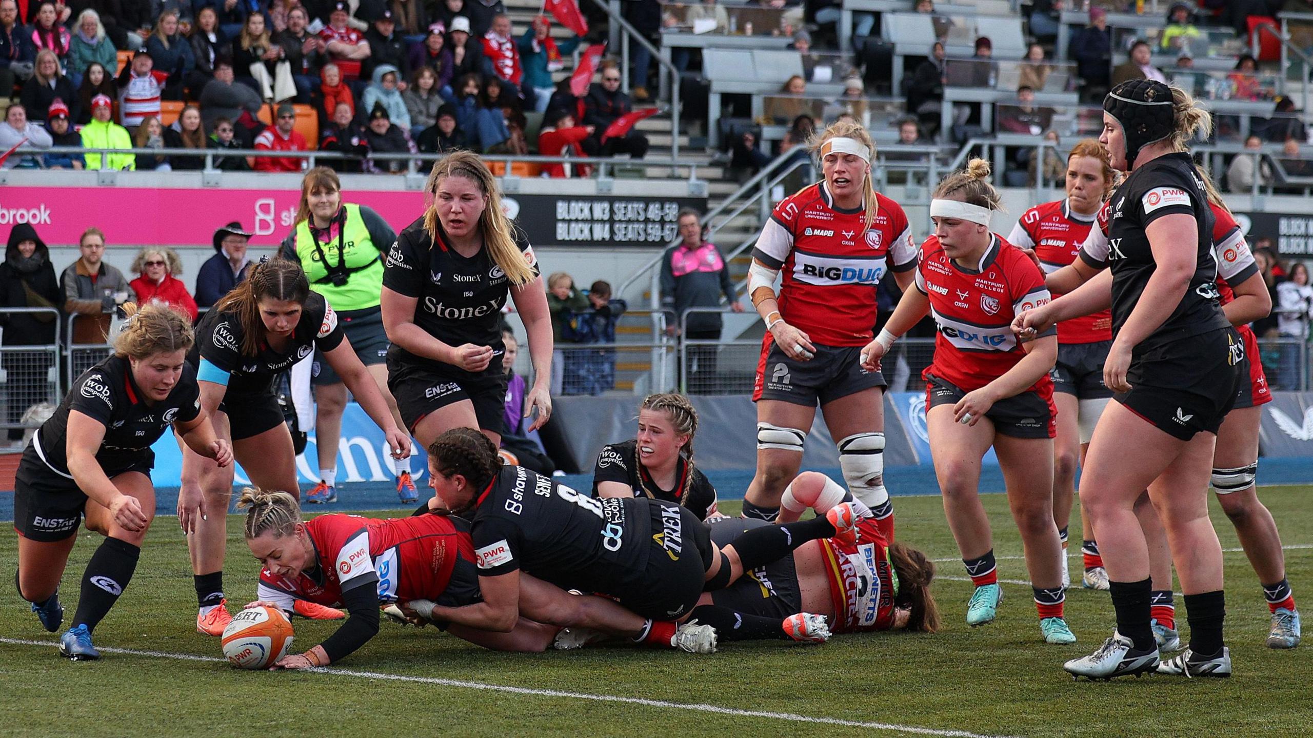 Natasha Hunt (third left) dives over the line under a tackle to score a try during the PWR final as players from Saracens and Gloucester-Hartpury look on