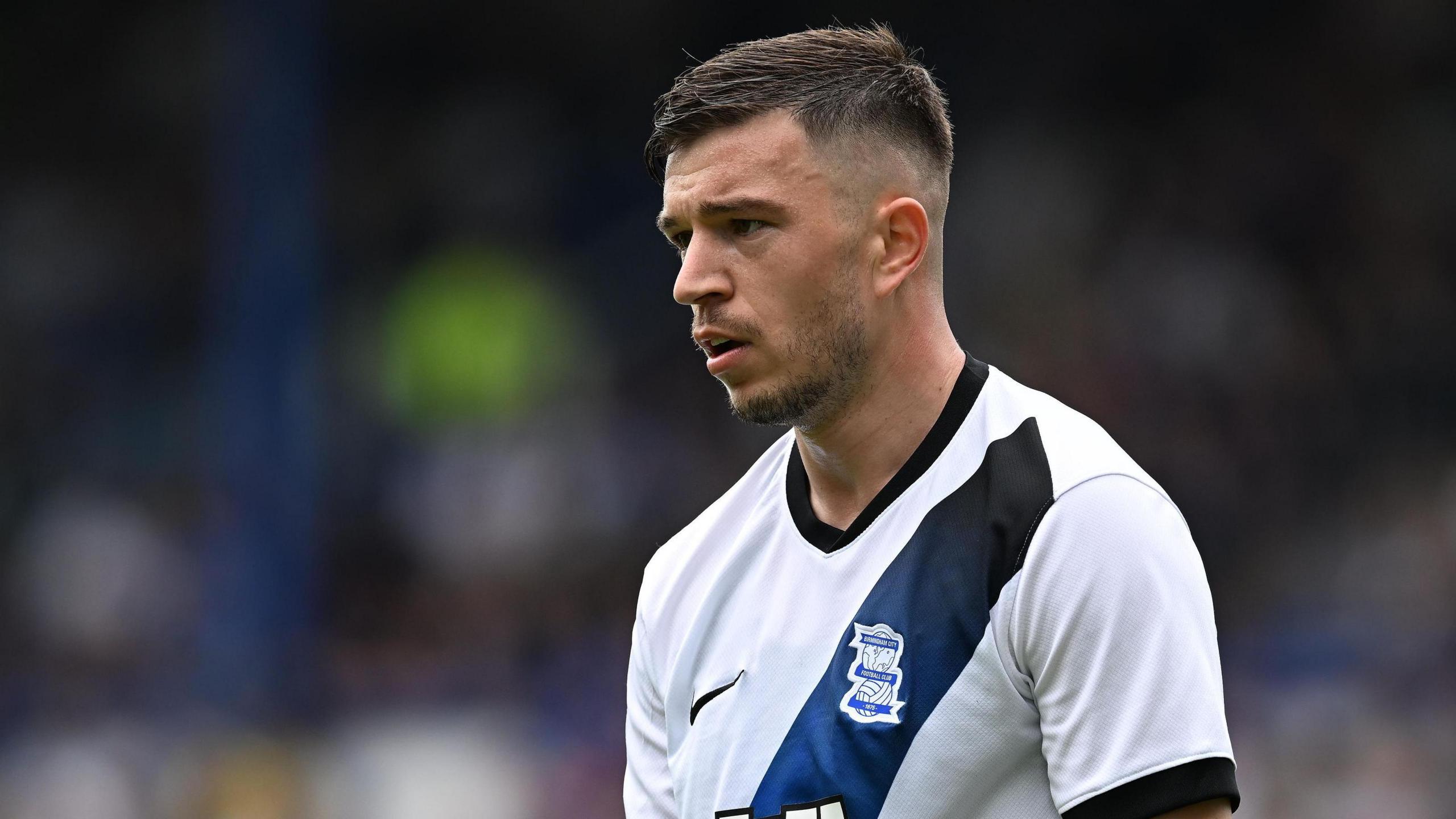 Kai Wagner in action for Birmingham City wearing a white away shirt with a dark blue and black sash.