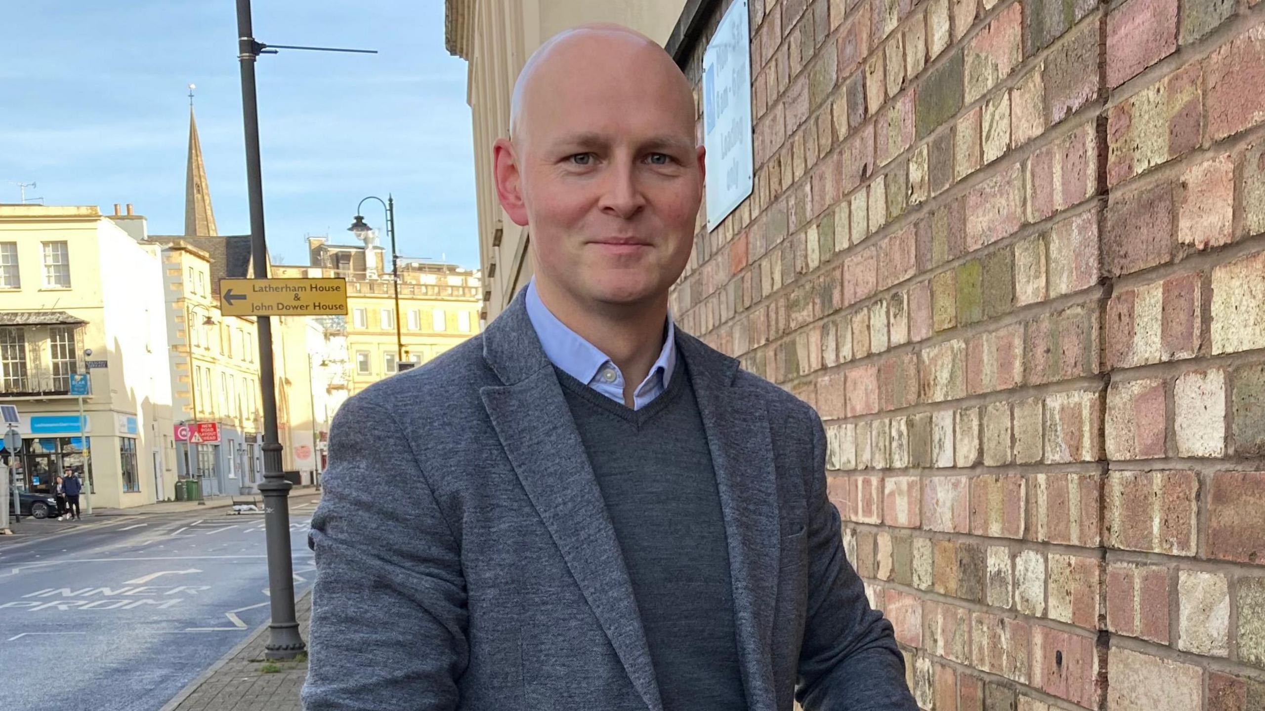 Max Wilkinson stood near a brick wall in Cheltenham town centre