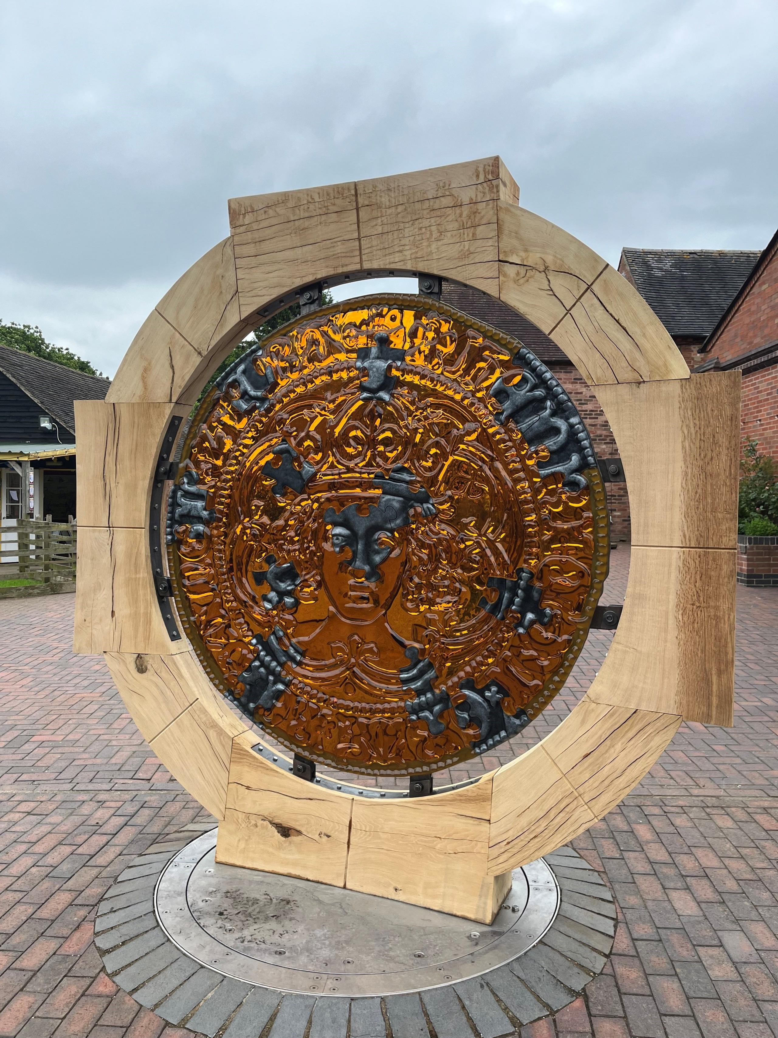 A large gold circle with an engraving of King Richard III. It is encircled by an oak ring and based on a grey base.