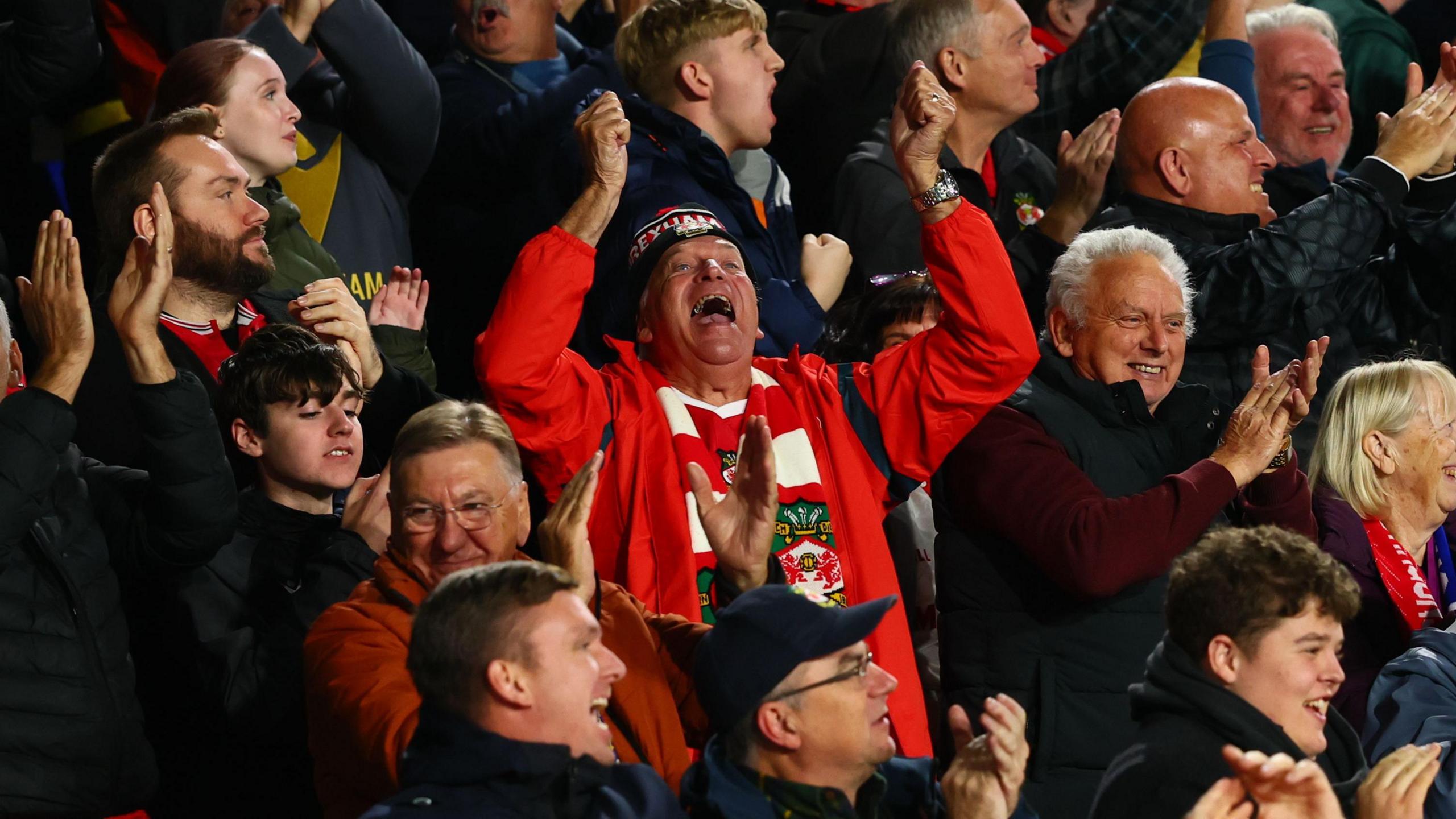 Wrexham fans celebrate in the away end at the King Power Stadium