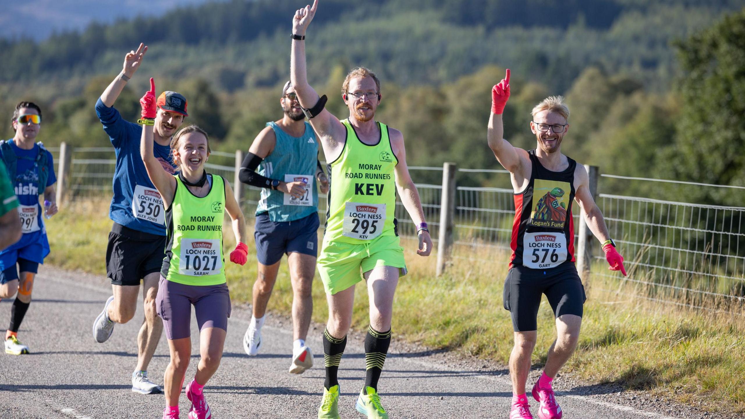 make and female runner point to the sky 