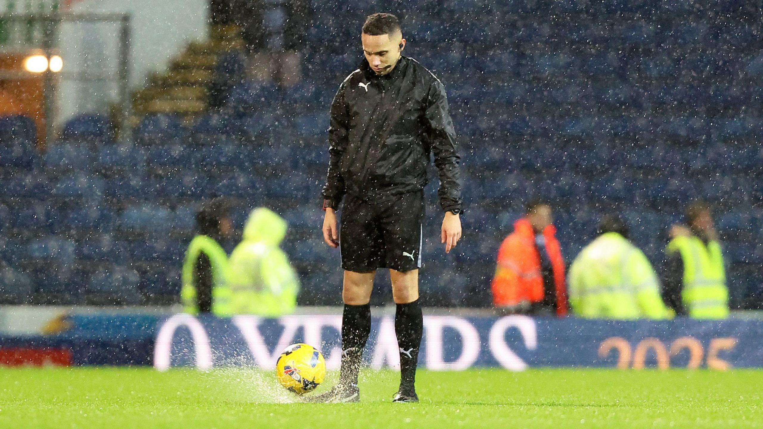 Referee Ruebyn Ricardo tries the bounce test and abandons the game during Blackburn Rovers' Championship fixture with Sheffield Wednesday