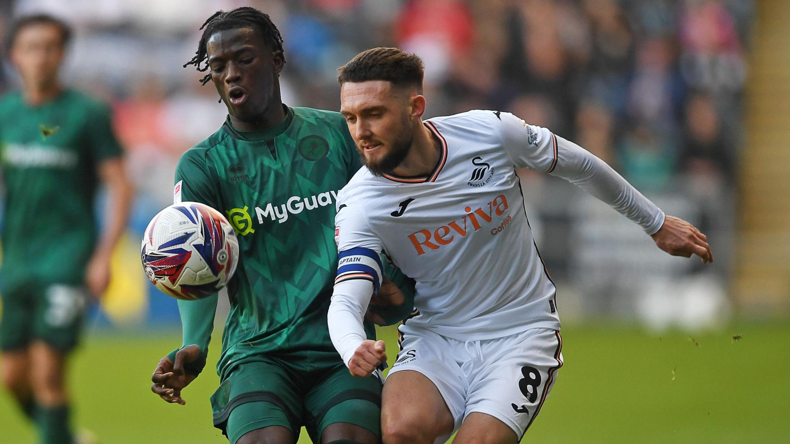 Swansea captain Matt Grimes looks to hold off Millwall's Romain Esse