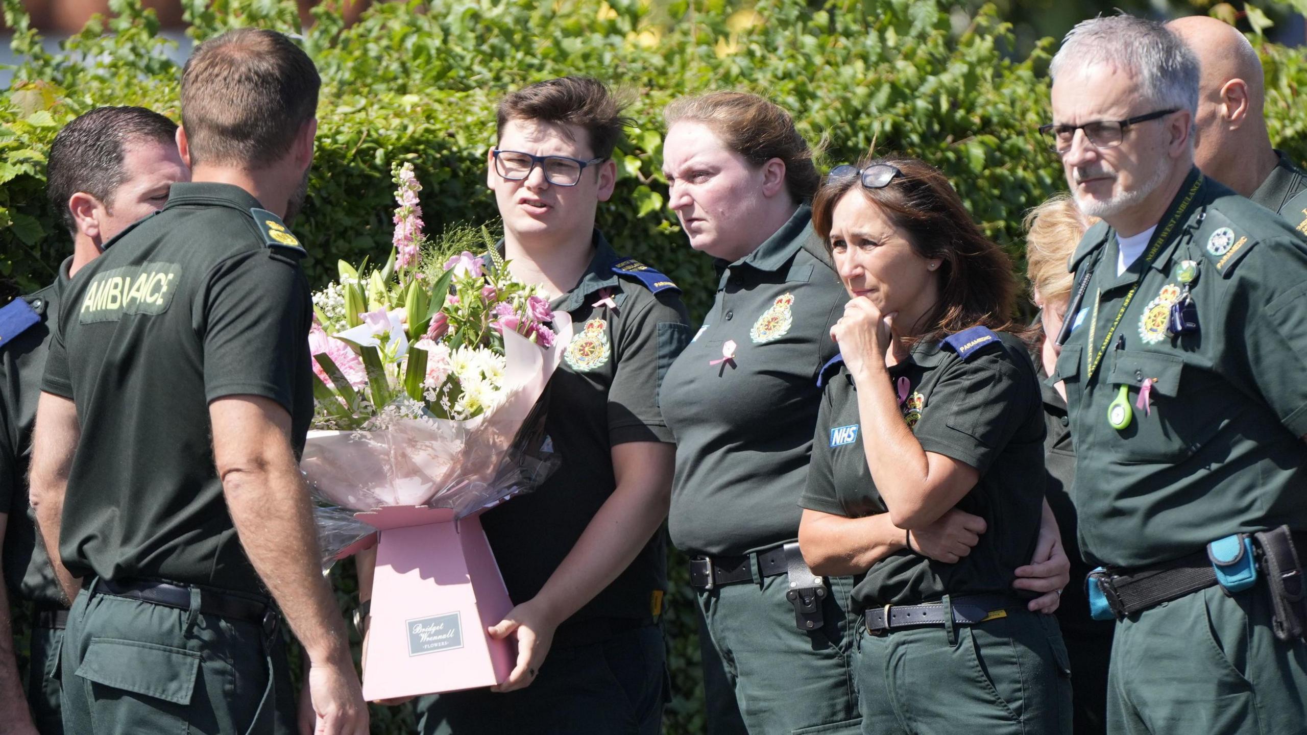 Paramedics outside St Patrick's Church with pink bouquet