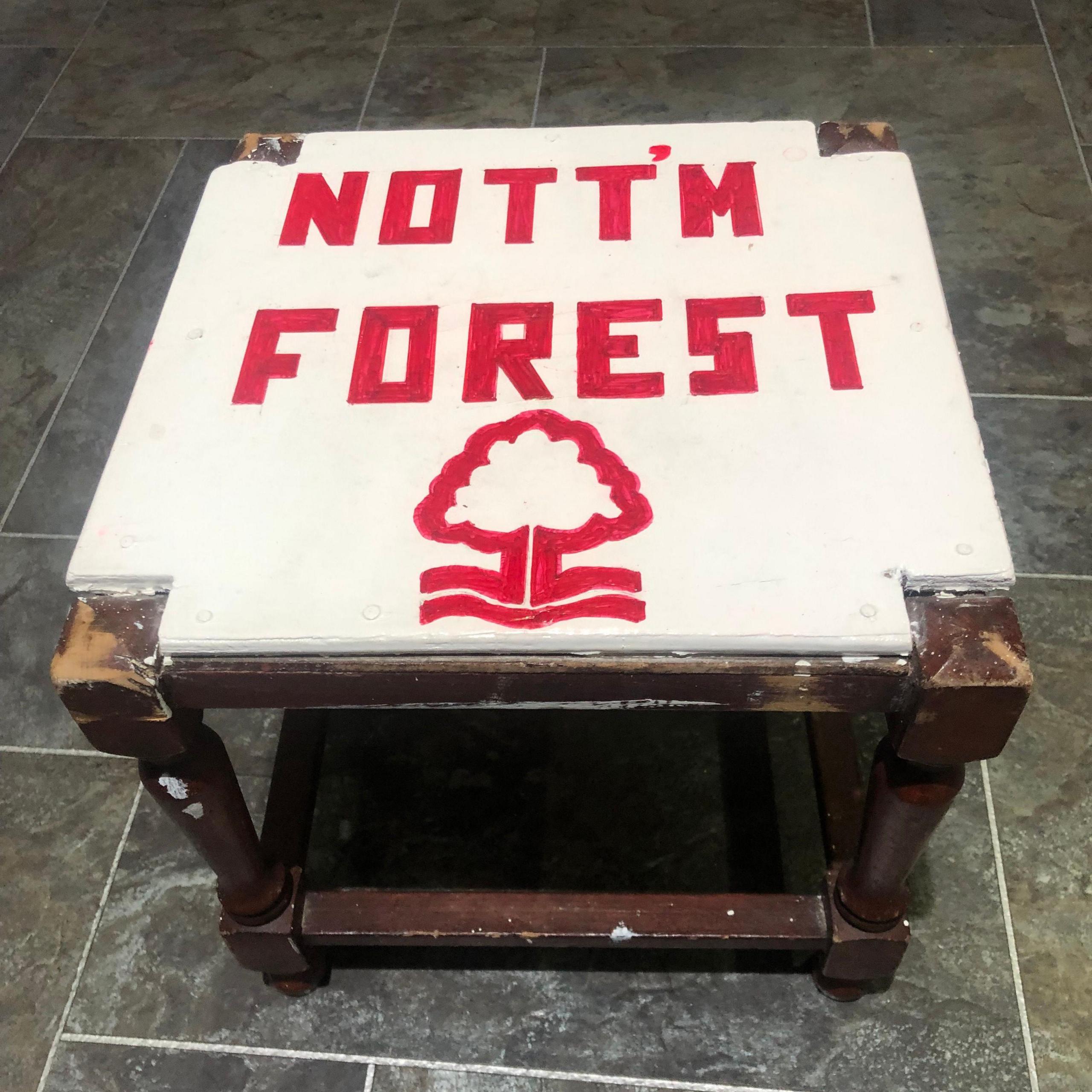 A picture of a stool with a white seat and the words Nott'm Forest and the club crest on