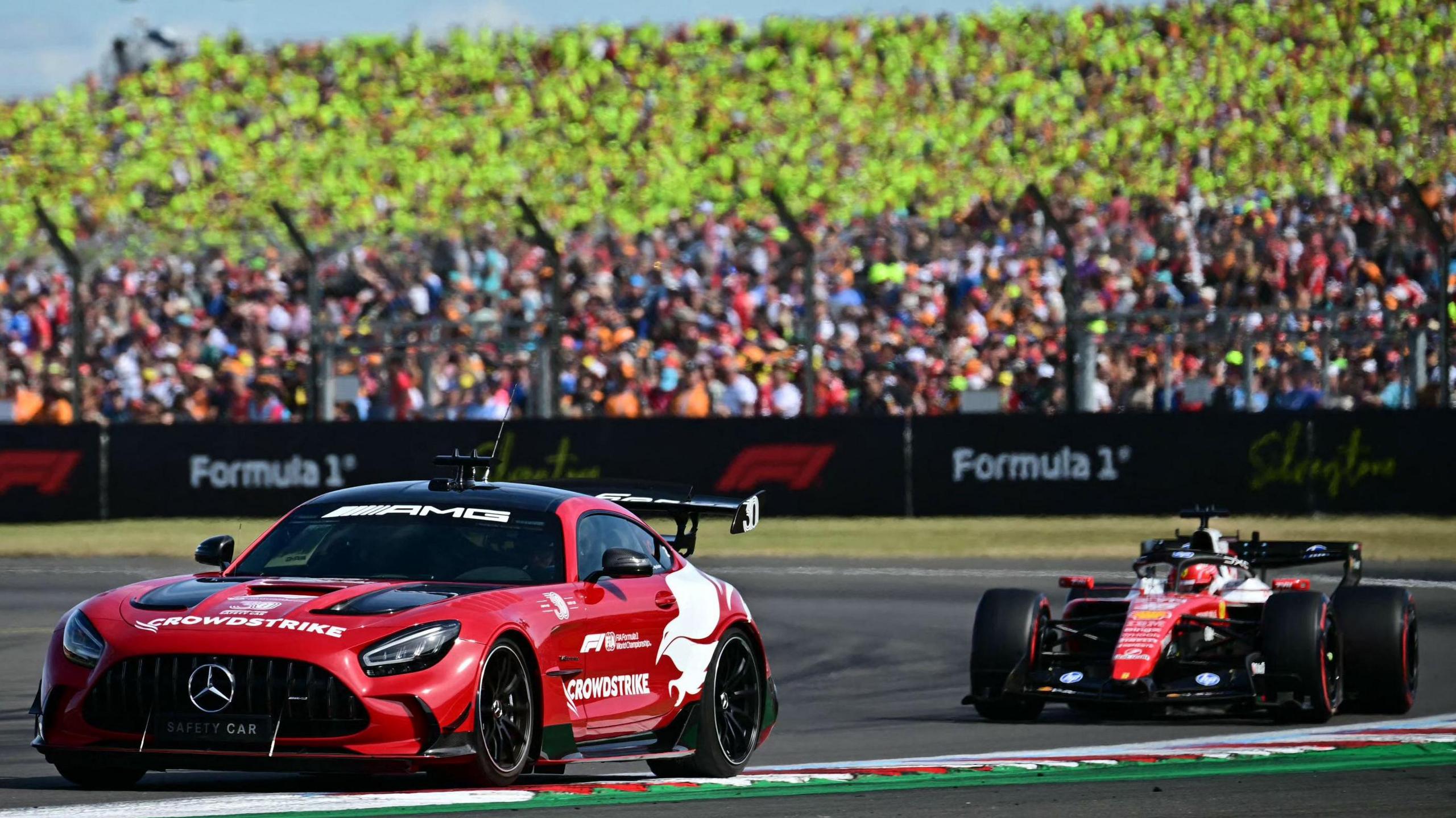 The safety car with eventual race winner Charles Leclerc, of Ferrari, immediately behind in the closing stages of the British Grand Prix