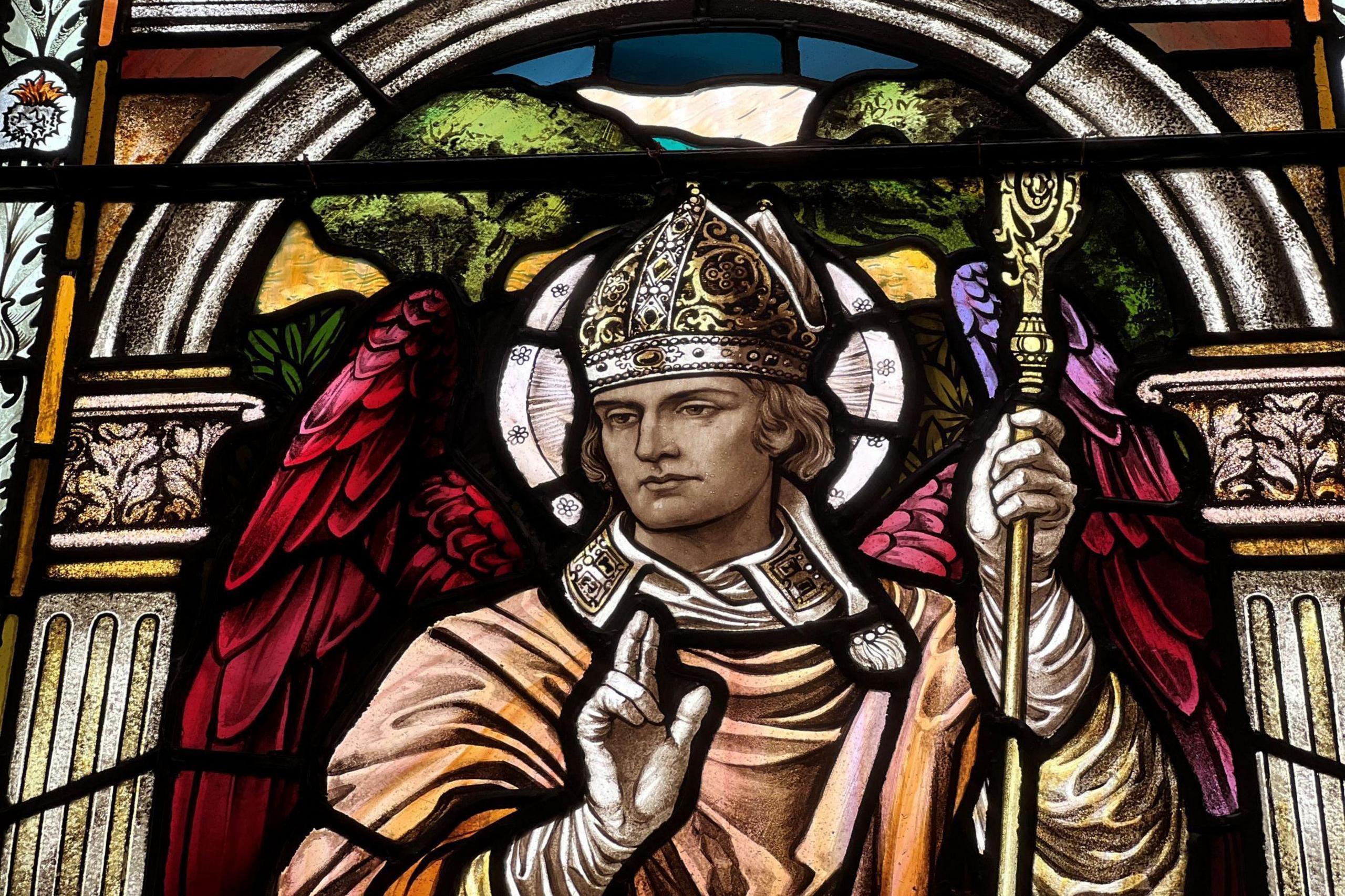 Image of a religious figure clad in orange robes holding a gold sceptre