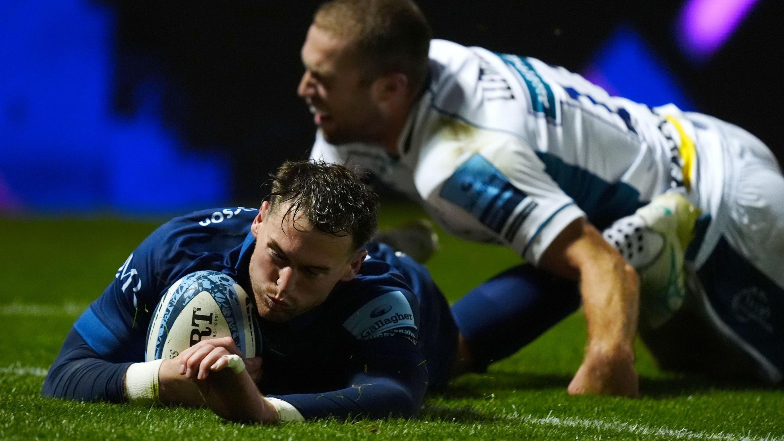 Tom Roebuck dives over the try line to score Sale's first try against Gloucester