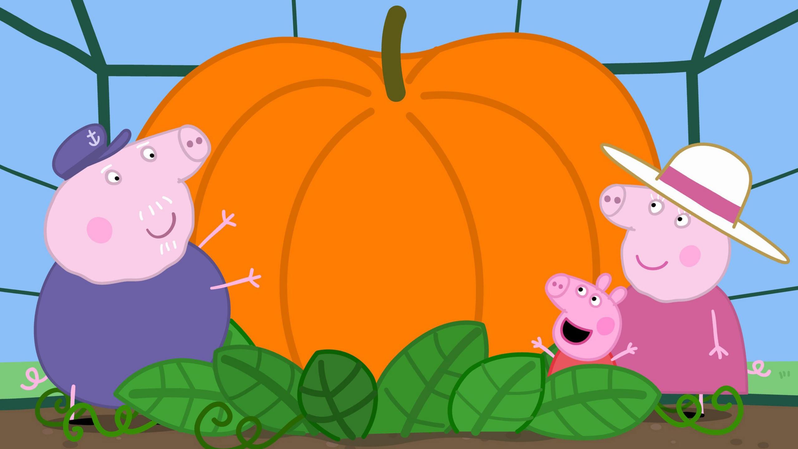 Grandpa Pig, Peppa and Mummy Pig with a giant pumpkin in a scene from children's TV show Peppa Pig