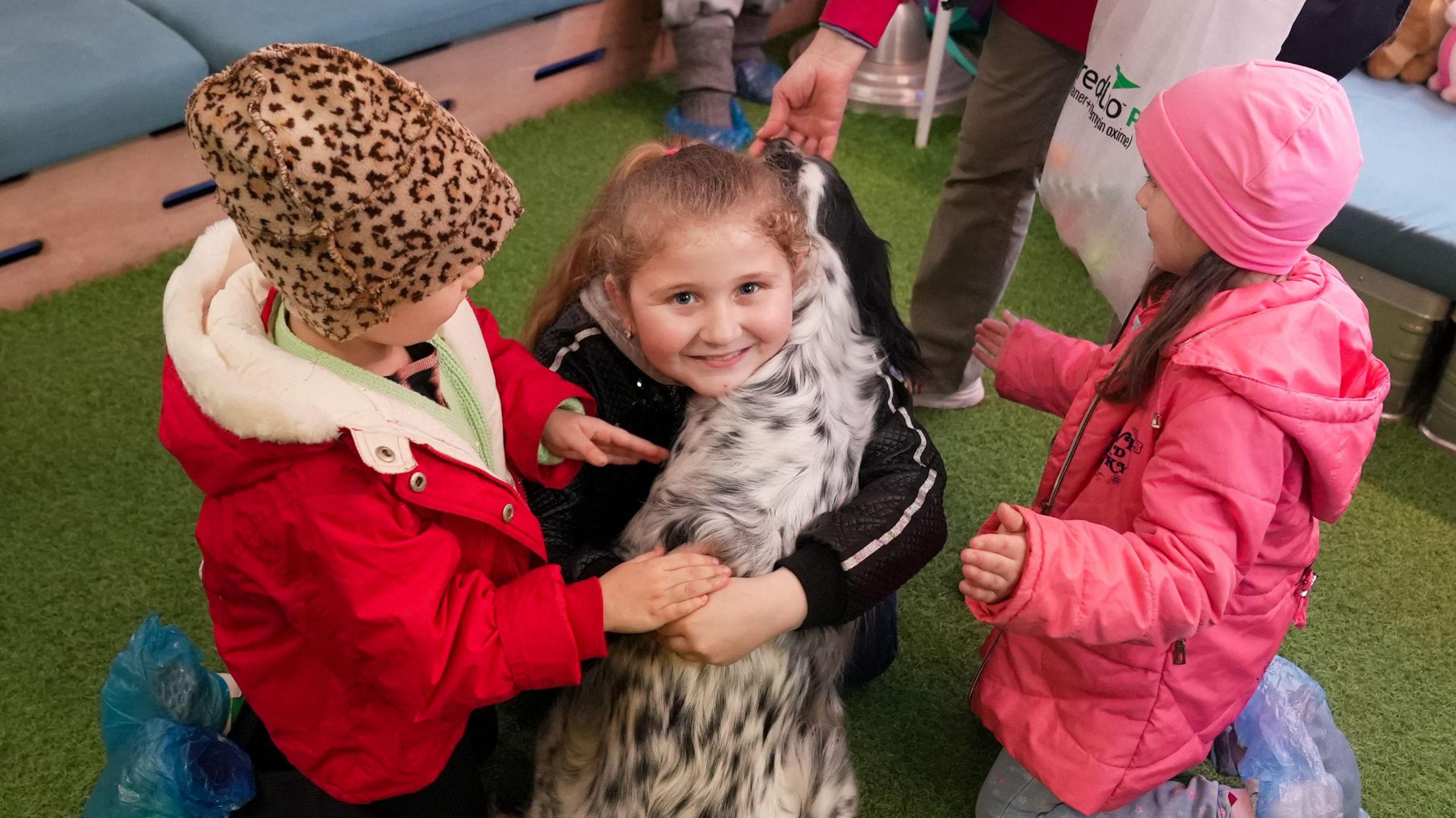 Angelina cuddles a dog during a pet therapy session