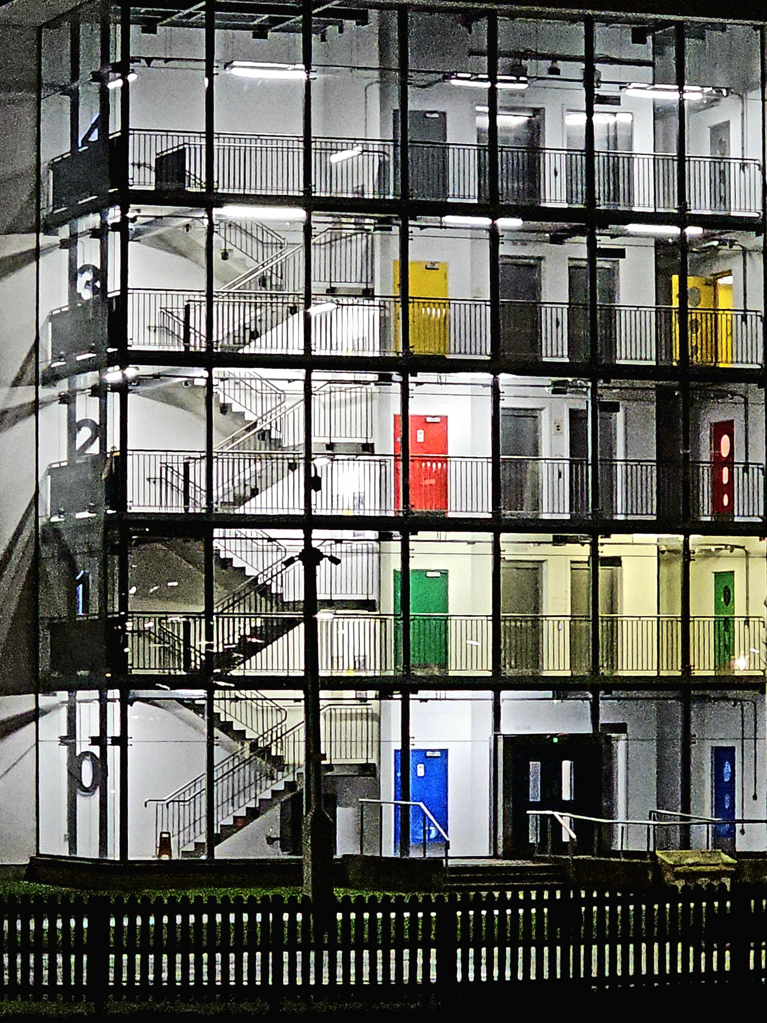 A set of stairs and colourful doors across a number of storeys