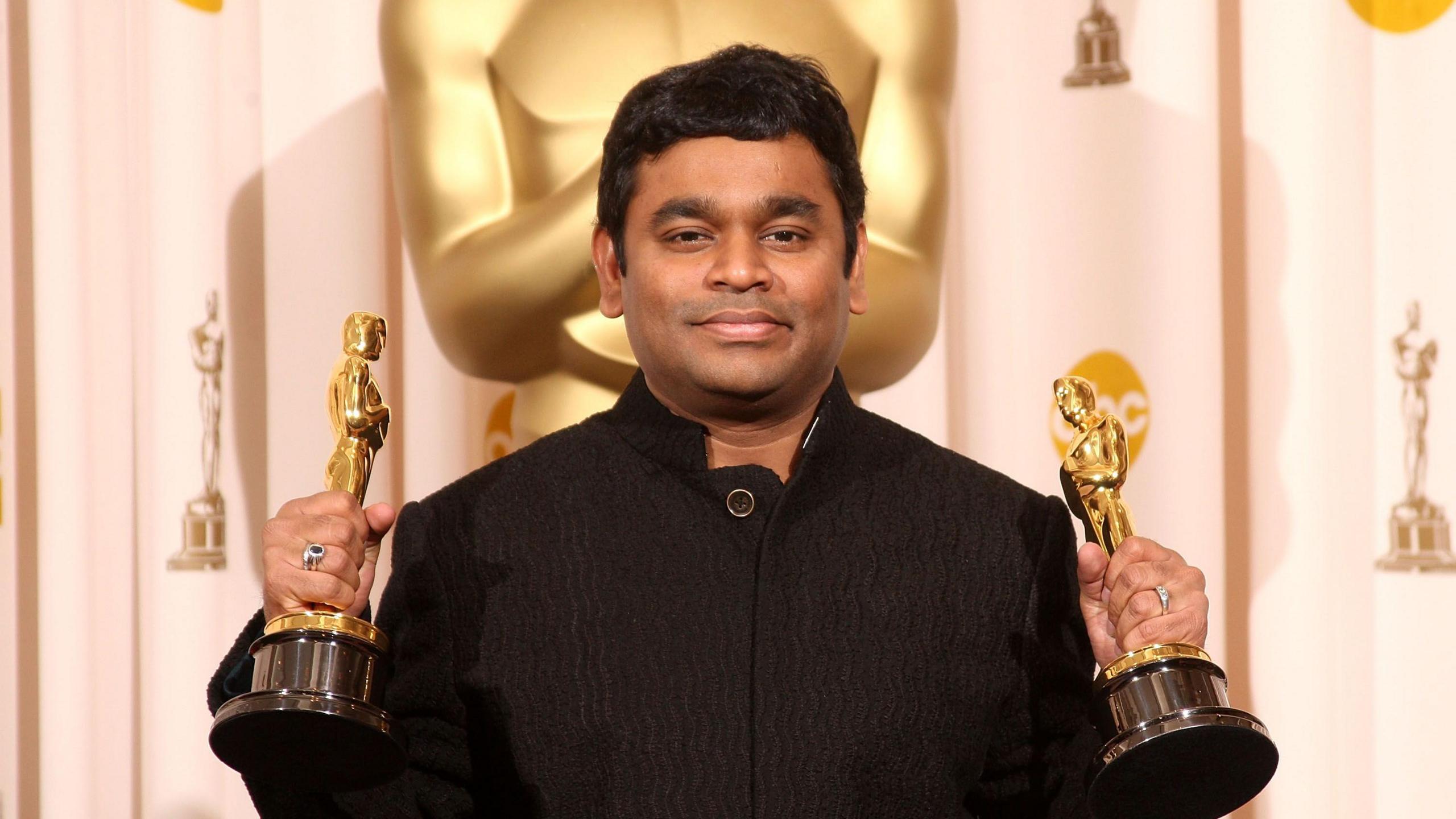 AR Rahman, a man wearing a black outfit, holding the two golden Oscars he won in 2009 for the film Slumdog Millionaire