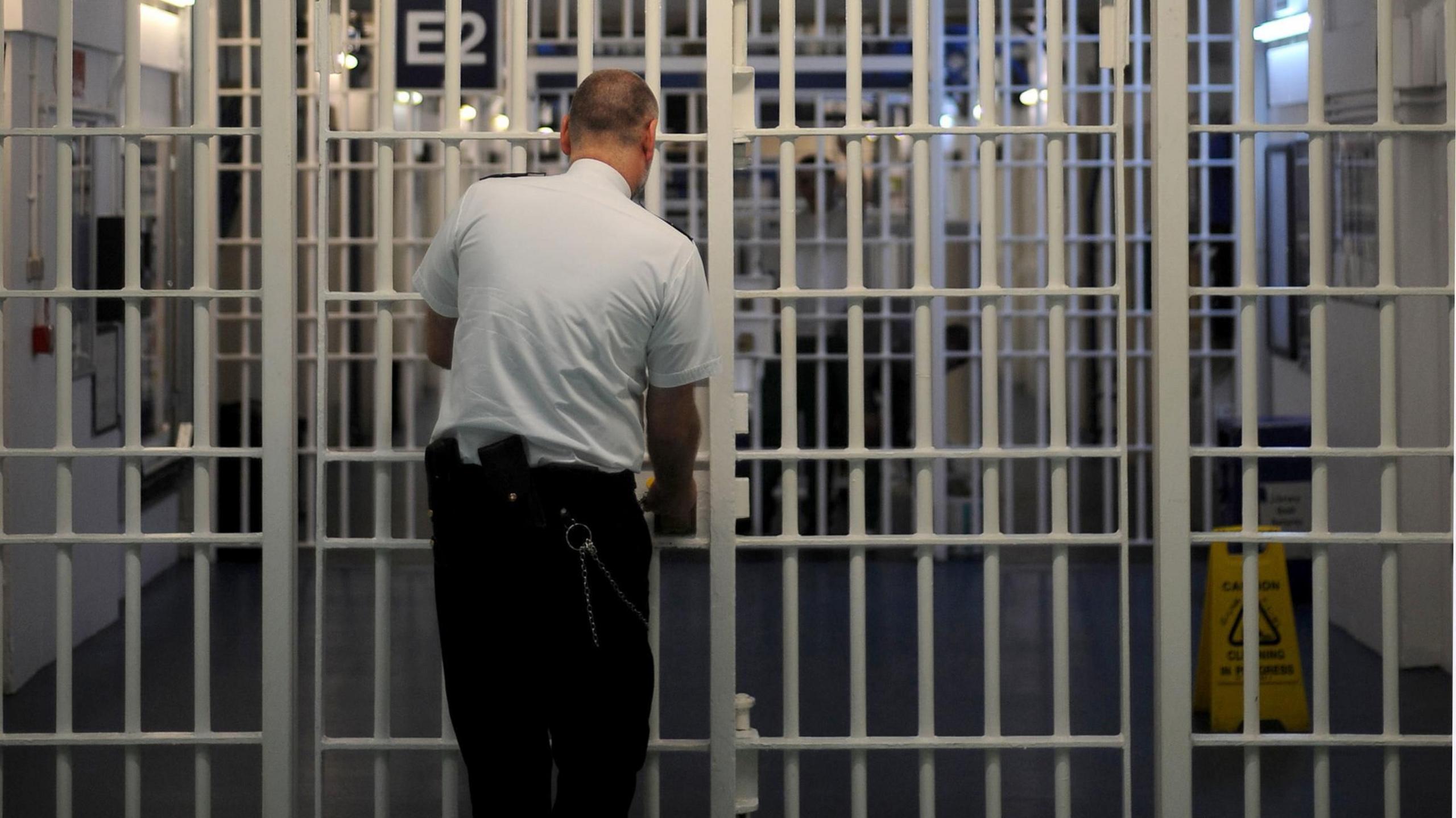 Prison guard locking gate