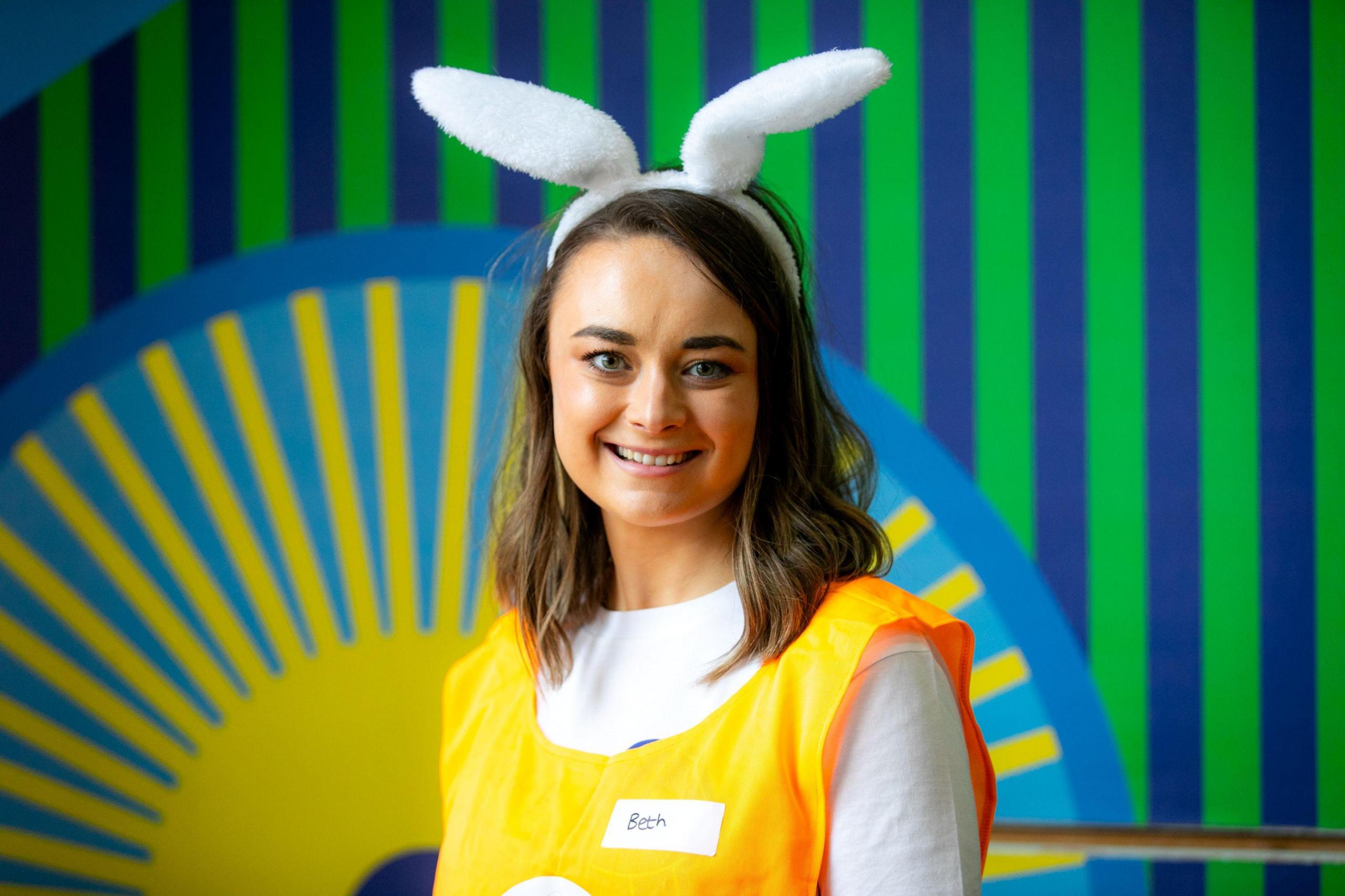 Beth wearing a headband with white rabbit ears on it
