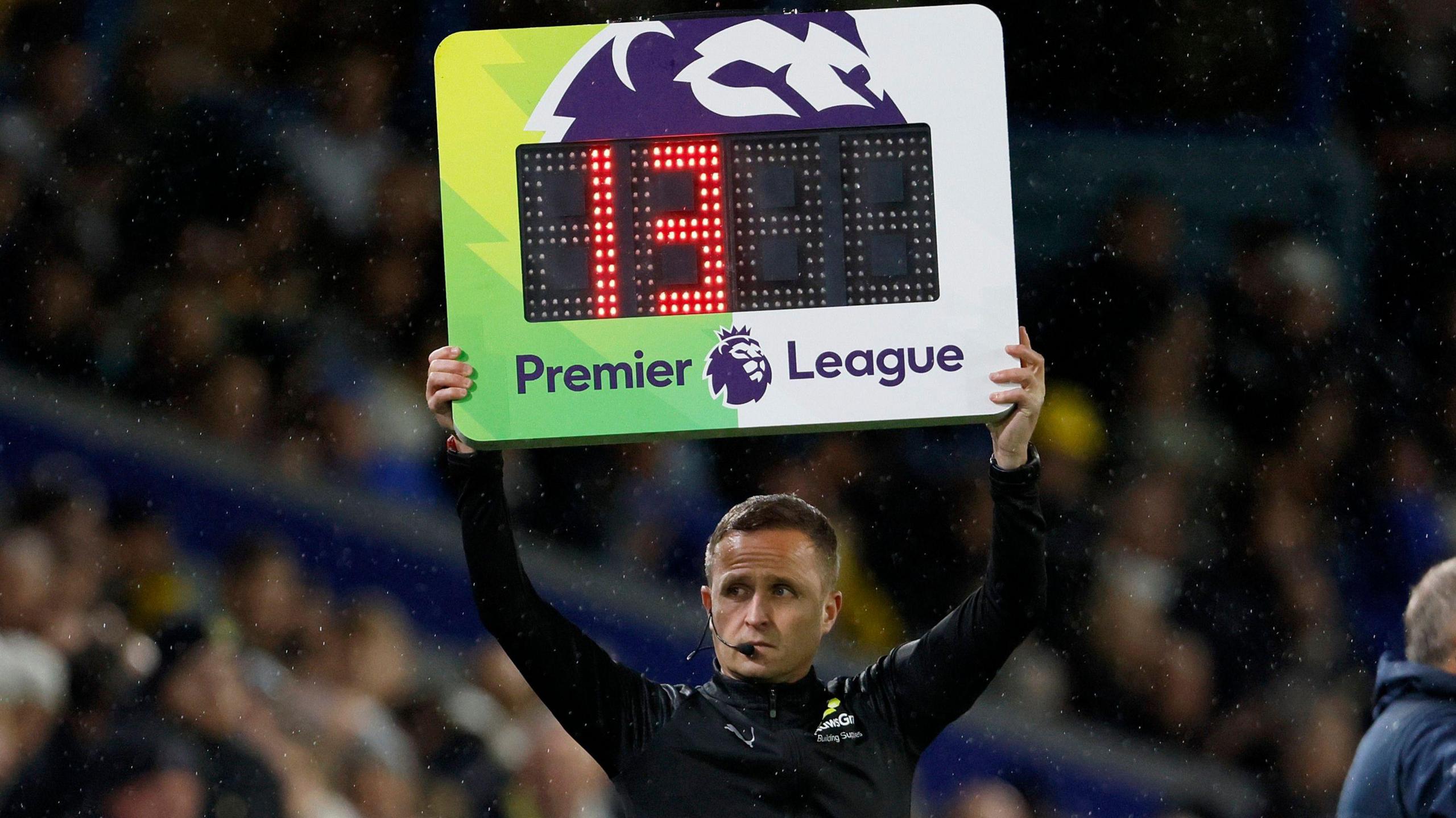 A fourth official holds up the board for additional time