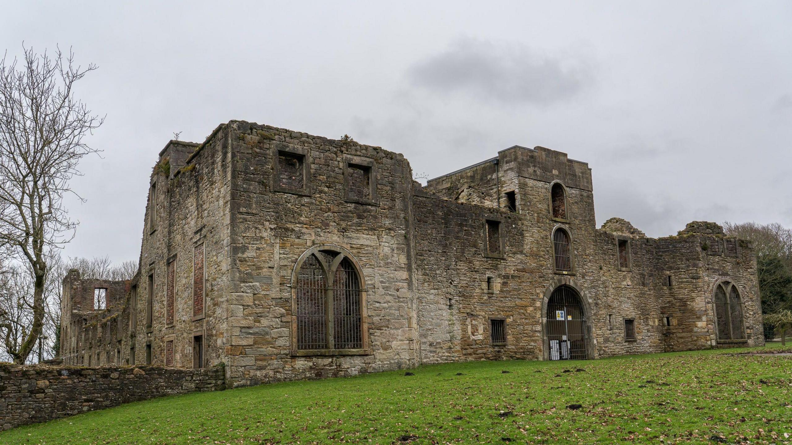 Workington Hall, which is a castle ruin, on a cloudy day.