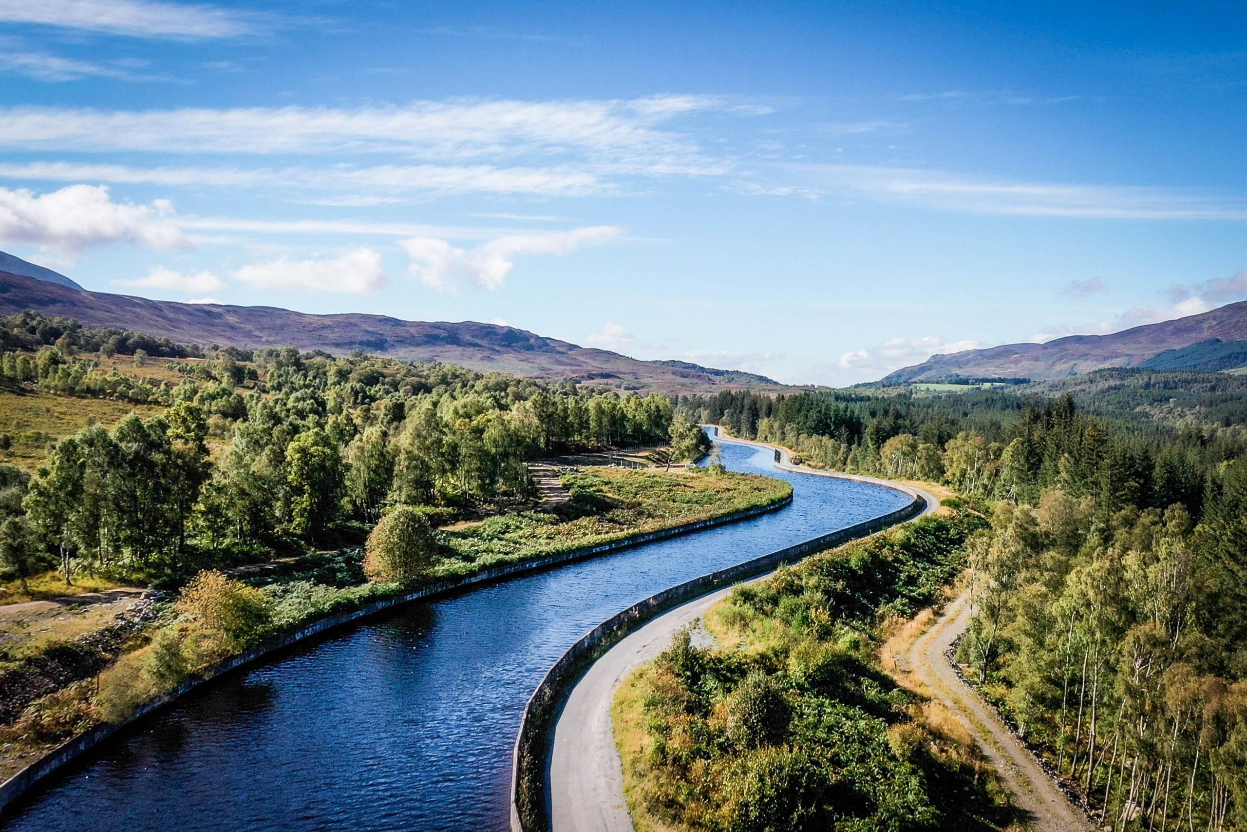 An open water channel, which looks like a canal, carries water from a dam at the Dunalastair Reservoir