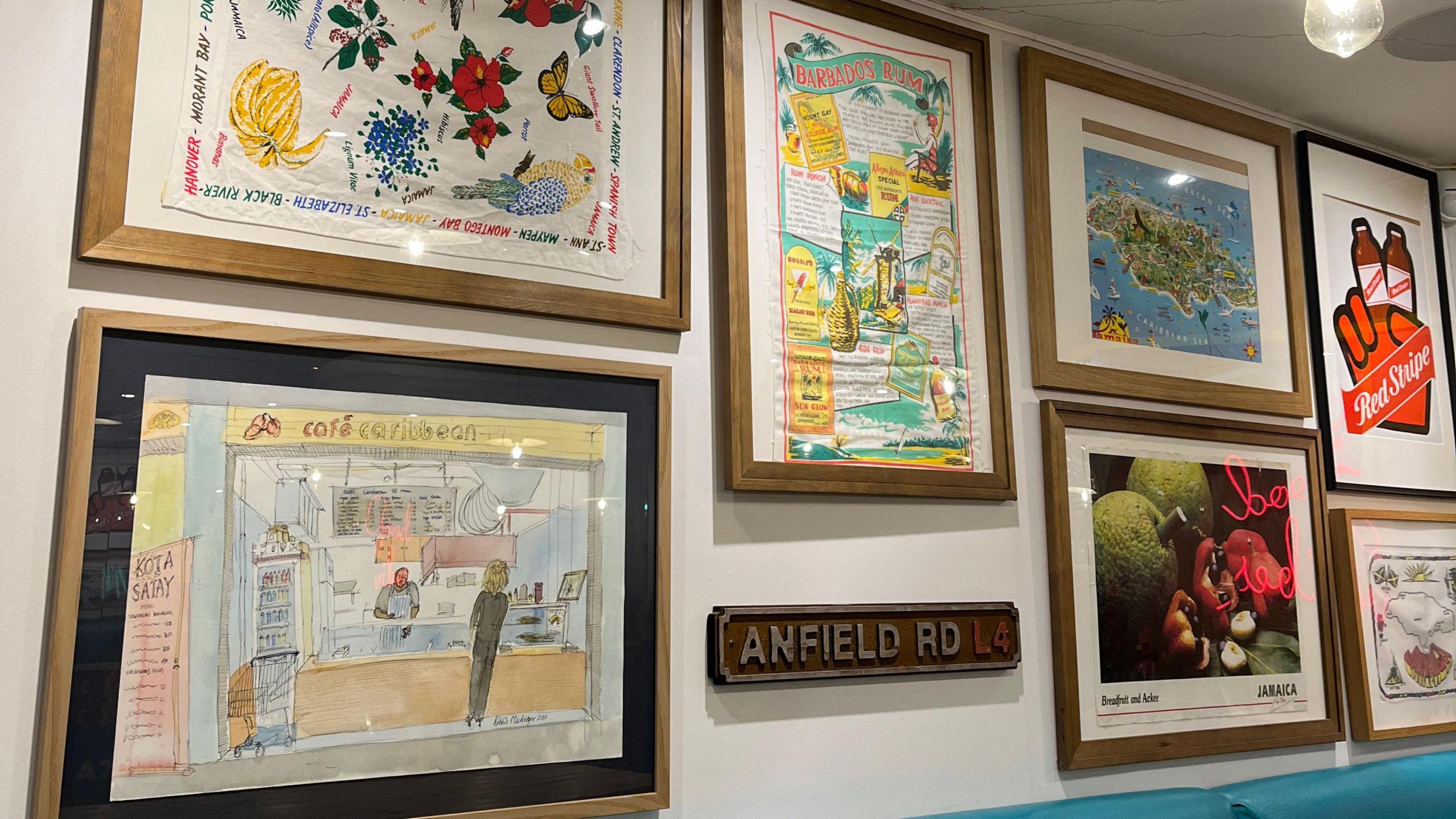 A collection of prints, framed and pinned on the wall inside the cafe.