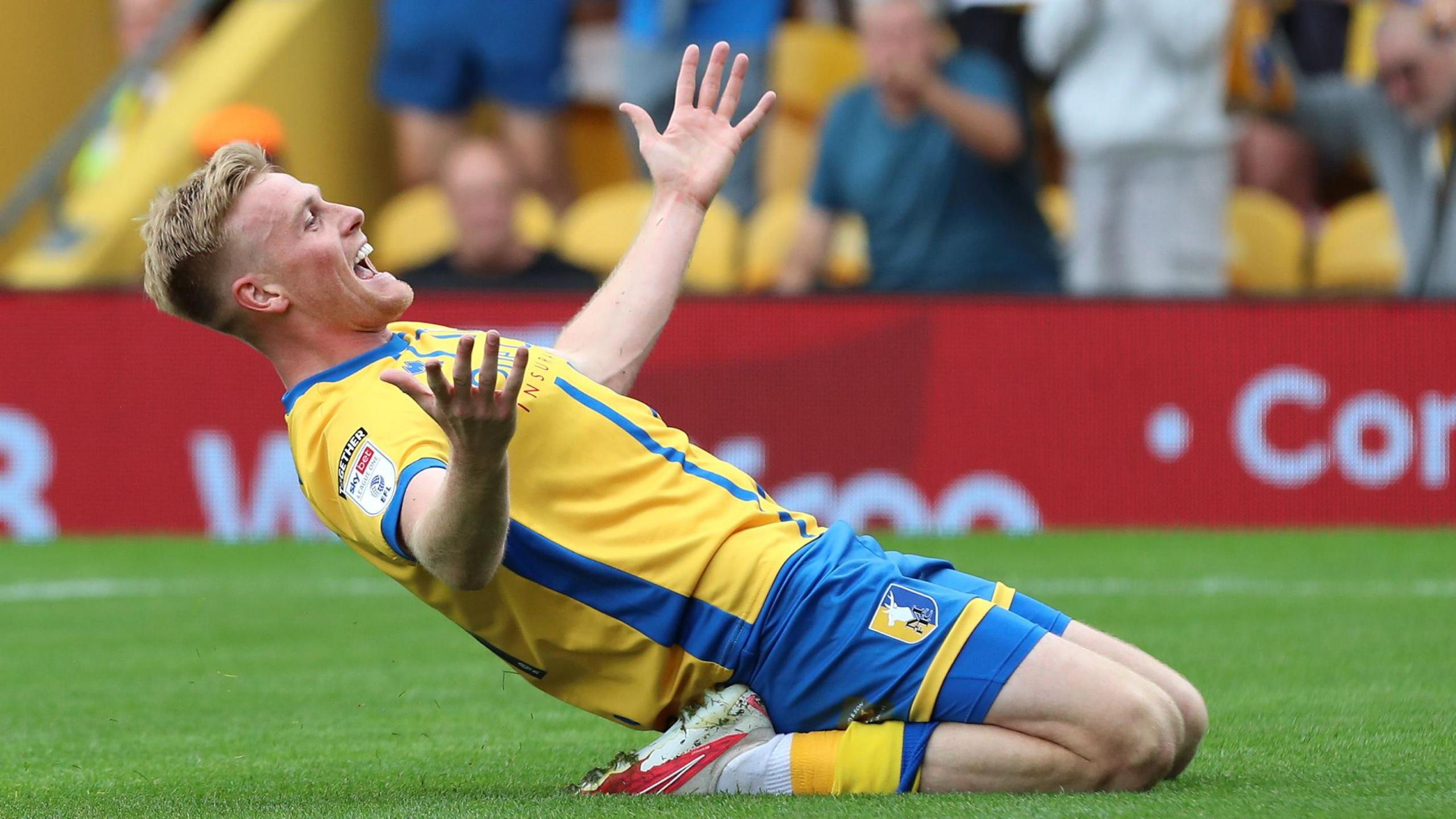 Will Evans celebrates scoring Mansfield's third goal against Leyton Orient