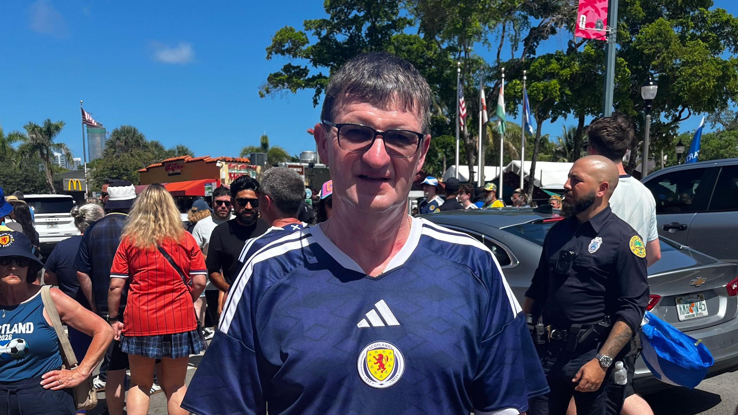 A man wearing glasses and a Scotland top.